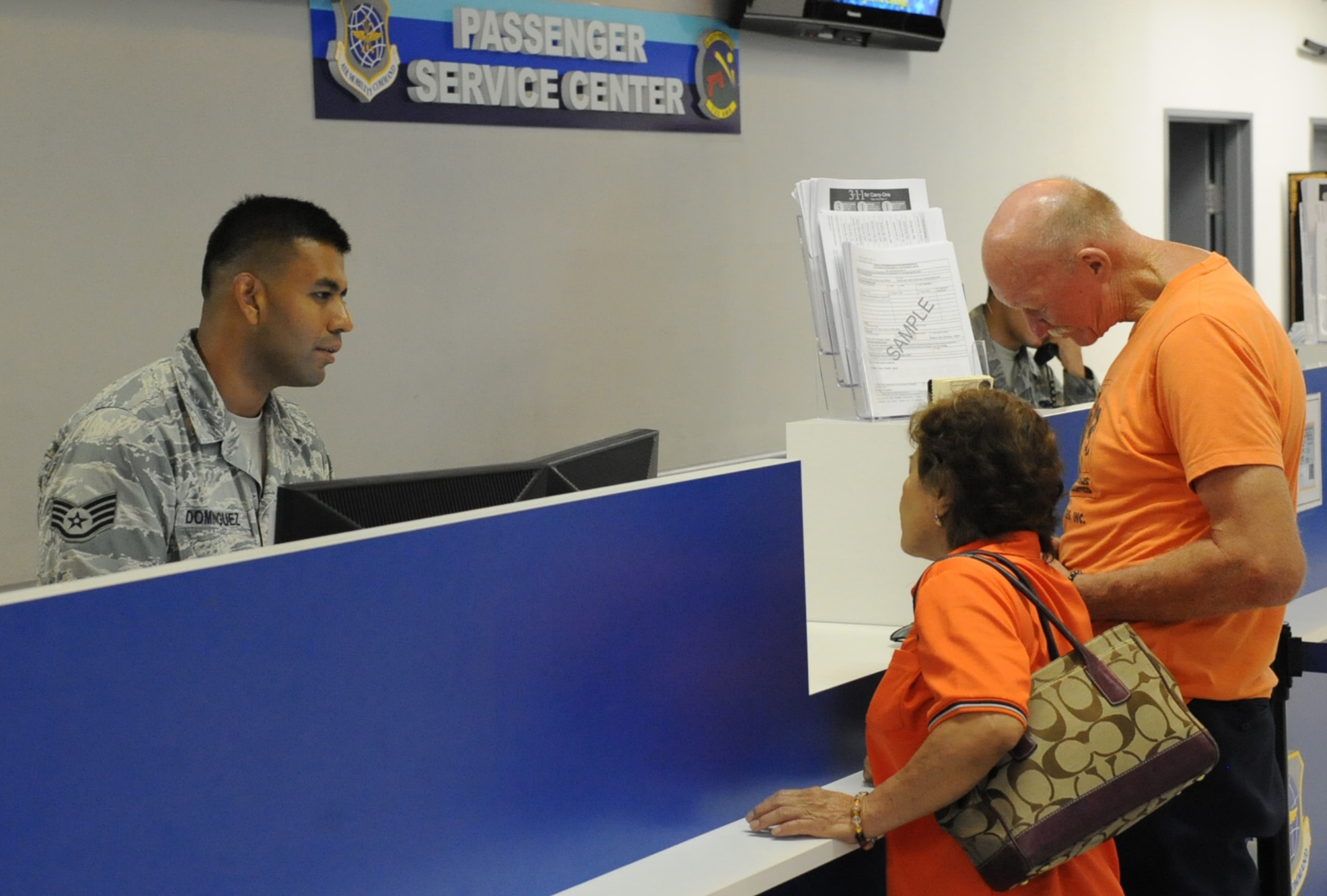 U.S. Air Force Staff Sgt. Heriberto Dominguez, 733rd Air Mobility Squadron passenger service supervisor, assists customers scheduling their flight using the Patriot Express on Kadena Air Base, Japan, Sept. 16, 2014. The aerial port section of the 733rd AMS covers the transportation of everything from cargo to passengers. (U.S. Air Force photo by Airman 1st Class Zackary A. Henry/Released)