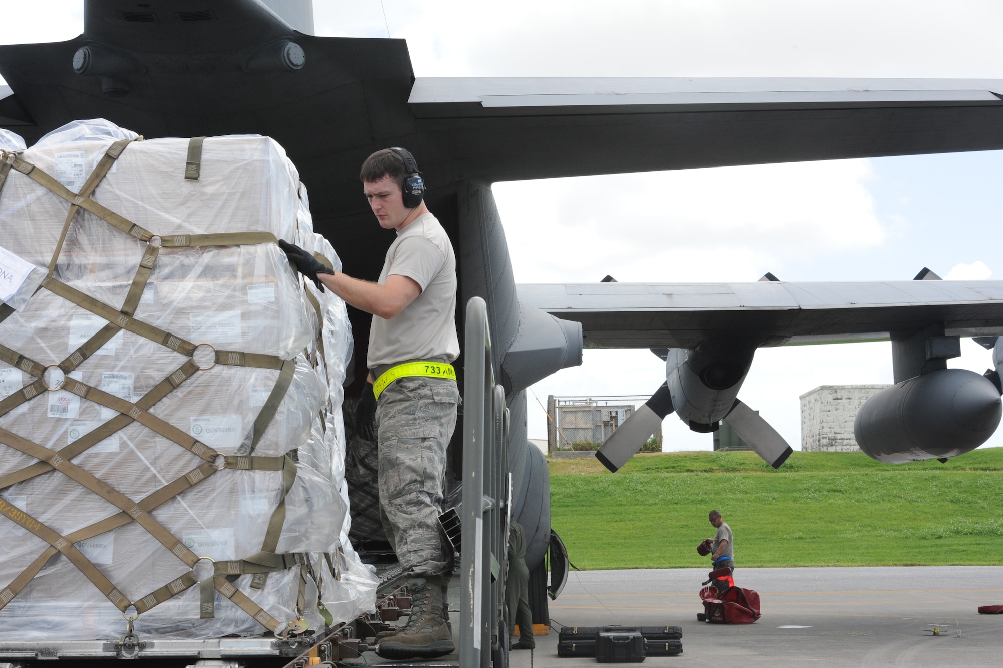 U.S. Air Force Airman 1st Class Colin Bradley, 733rd Air Mobility Squadron aircraft service specialist, follows cargo onto a tonner on Kadena Air Base, Japan, Sept. 16, 2014. The aerial port section of the 733rd ensures the safe and timely arrival and departure of cargo on the heavy aircrafts. (U.S. Air Force photo by Airman 1st Class Zackary A. Henry/Released)