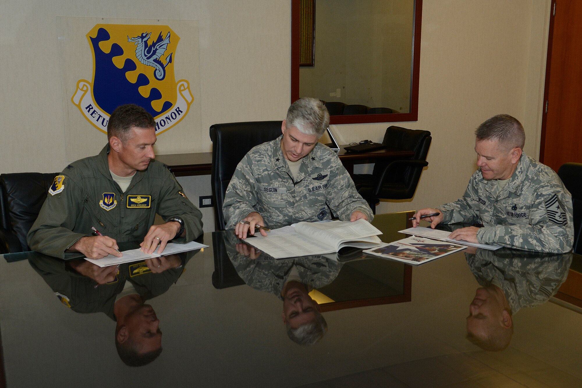 (From left) Col. Gregory Kreuder, 31st Fighter Wing vice commander, Brig. Gen. Barre Seguin, 31st FW commander, and Chief Master Sgt. Mark Batzer, 31st FW command chief, take a moment to fill out Combined Federal Campaign pledge forms, Sept. 16, 2014 at Aviano Air Base, Italy. Team Aviano members can donate to more than 2,600 charitable organizations by cash, check, payroll deduction or online payments from now through November to the organization of their choosing. With the help of volunteers, the Aviano CFC Overseas team has organized several events such as an exercise-a-thon and a movie night, to raise awareness and donations for the campaign. (U.S. Air Force photo/Staff Sgt. Jessica Hines)