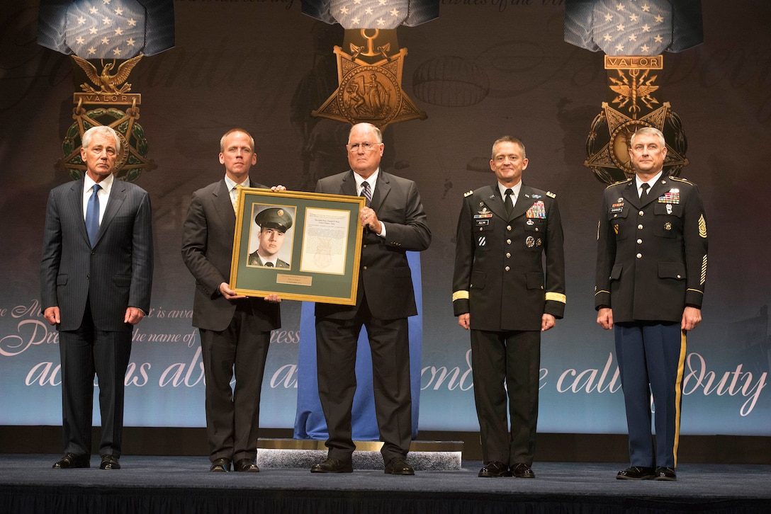 Defense Secretary Chuck Hagel, left, Undersecretary of the Army Brad R. Carson, center left, William Sloat, brother of Army Spc. 4 Donald P. Sloat, center, Vice Chief of Staff of the Army Gen. Daniel B. Allyn, center right, and Sgt. Maj. of the Army Raymond F. Chandler III, right, pose for a photo during the Hall of Heroes ceremony at the Pentagon, Sept. 16, 2014. Spc. 4 Sloat was posthumously awarded the Medal of Honor and inducted into the Hall of Heroes.