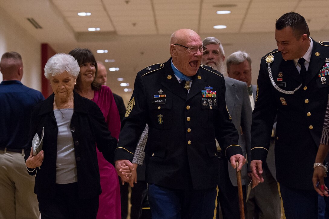 Medal of Honor recipient retired Army Command Sgt. Maj. Bennie G. Adkins, center, holds hands with his wife, Mary, and shares a laugh with a soldier after being inducted into the Hall of Heroes during a ceremony at the Pentagon, Sept. 16, 2014. 