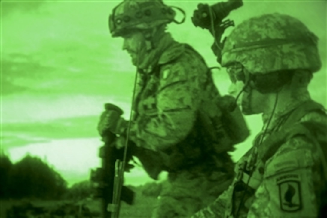 As seen through a night-vision device, a U.S. soldier, foreground, assists Italian paratroopers before an air assault during NATO exercise Steadfast Javelin II on Lielvarde Airbase, Latvia, Sept. 7, 2014. The soldier is assigned to the 12th Combat Aviation Brigade. The exercise, which involves more than 2,000 troops from nine nations, takes place across Estonia, Germany, Latvia, Lithuania and Poland. 