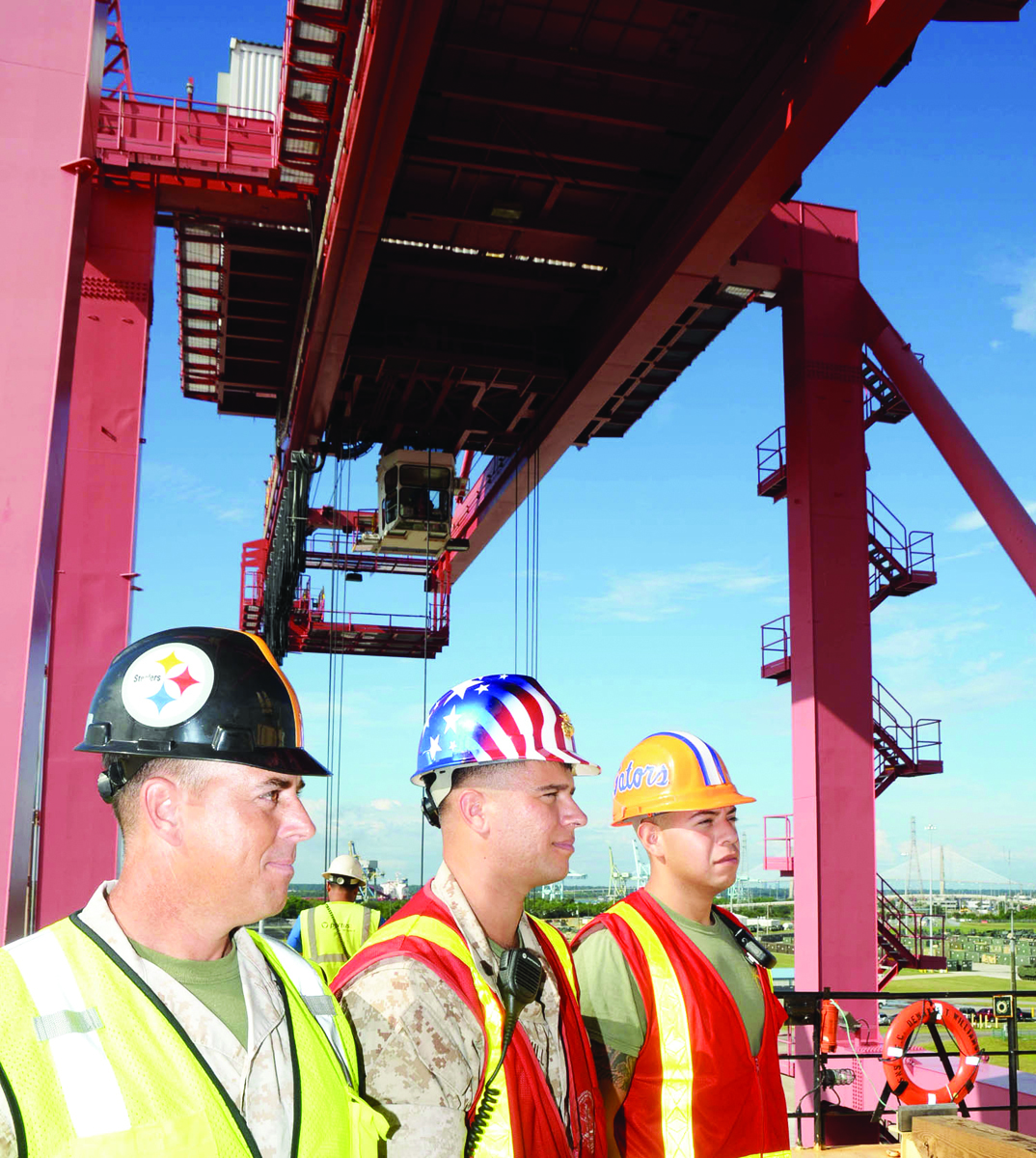 Members of Port Operations, Blount Island Command, Jacksonville, Fla., from left are: Capt. Jonathan Cashman, officer-in-charge; Staff Sgt. Michael Stull, embarkation chief; and Sgt. Edward Gonzalez, embarkation specialist; who supervise the offload of large metal containers. Filled with all types of military gear, stevedores offloaded the containers with heavy-duty cranes from within the United States Navy Ship Pfc. Dewayne T. Williams.