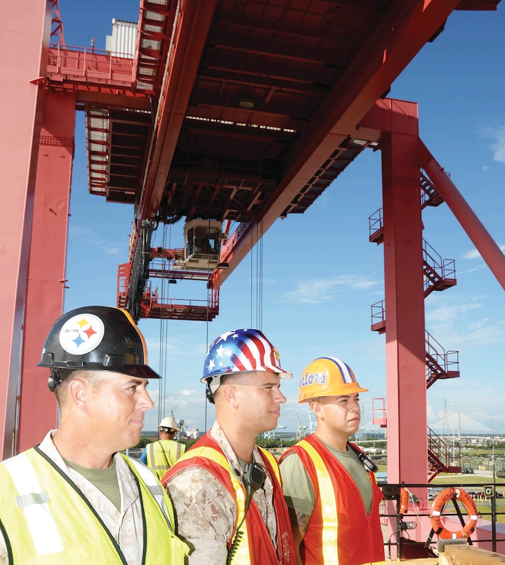 Members of Port Operations, Blount Island Command, Jacksonville, Fla., from left are: Capt. Jonathan Cashman, officer-in-charge; Staff Sgt. Michael Stull, embarkation chief; and Sgt. Edward Gonzalez, embarkation specialist; who supervise the offload of large metal containers. Filled with all types of military gear, stevedores offloaded the containers with heavy-duty cranes from within the United States Navy Ship Pfc. Dewayne T. Williams.