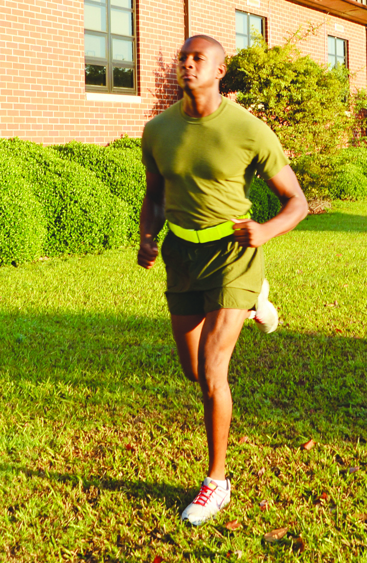 Sgt. Marcus Keyes, unit training management and funerals noncommissioned officer, Base Operations, is seen running correctly with a reflective belt, off the main roadway without earplugs.