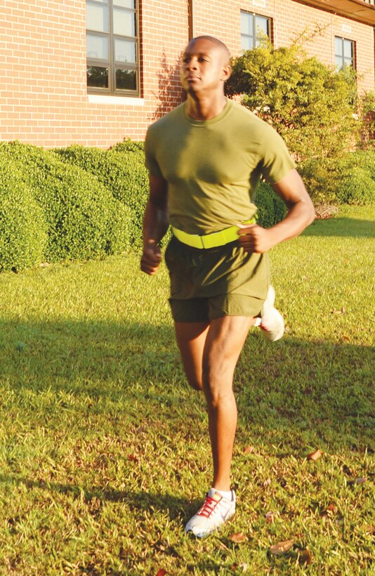 Sgt. Marcus Keyes, unit training management and funerals noncommissioned officer, Base Operations, is seen running correctly with a reflective belt, off the main roadway without earplugs.