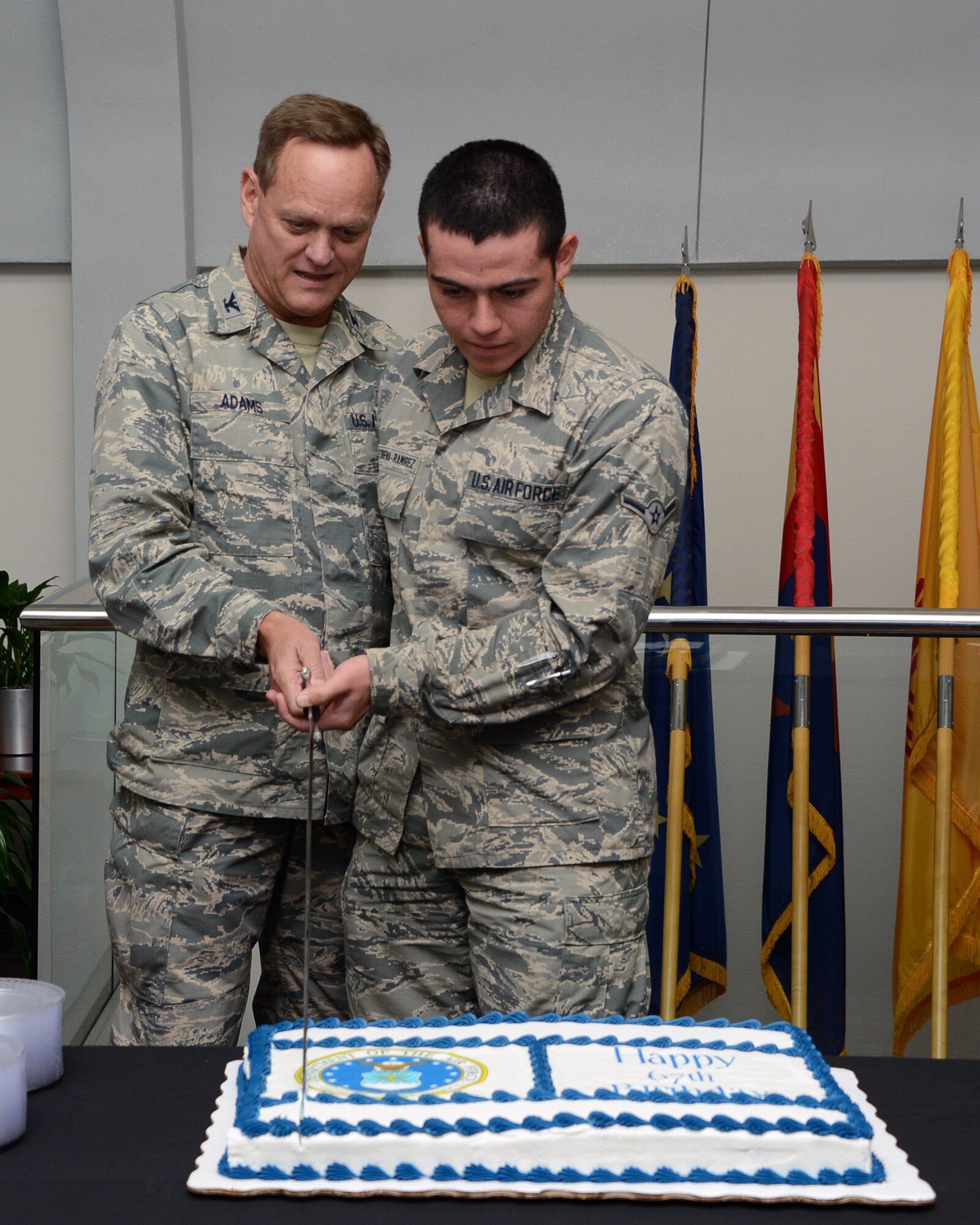 Chaplain (Col.) Scott Adams, Individual Mobilization Assistant to the command chaplain, and Airman Rickey Castorena-Ramirez, Air Force Special Operations Command Commander's Support Staff, cut the cake as the oldest and youngest Airmen in Headquarters AFSOC Sept. 18, 2014, Hurlburt Field, Fla. AFSOC held a cake-cutting ceremony in celebration of the Air Force's 67th birthday. (U.S. Air Force photo by Capt. Victoria Porto)
