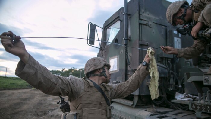 Cpls. Daniel R. Roca, left, and Jarrod R. Allen check the oil on a 7-ton truck Aug. 30 during Artillery Relocation Training Program 14-2 at the Yausubetsu Maneuver Area in Hokkaido, Japan. Marines working at the administrative logistics ordnance command maintained vehicles and equipment for three batteries during ARTP 14-2. Roca is from Germantown, Maryland, and an automotive organizational mechanic with 3rd Battalion, 12th Marine Regiment, 3rd Marine Division, III Marine Expeditionary Force. Allen is from Amarillo, Texas, and a motor vehicle operator with the battalion. (U.S. Marine Corps photo by Sgt. Matthew Manning/Released)