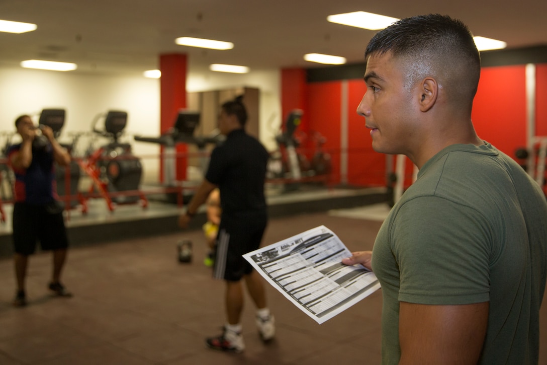 Cpl. Jonathan Soriano, a level one High Intensity Tactical Training instructor with Marine Aviation Logistics Squadron (MALS) 11, watches as his Marines perform kettle bell squats during a lunch-time physical training session at the HITT Center aboard Marine Corps Air Station Miramar, Calif., Sept. 8. Randy Saldivar, a Return-to-Readiness program trainer, helped teach Soriano much of what he knows as an instructor, and continues to mentor him during his physical training sessions.