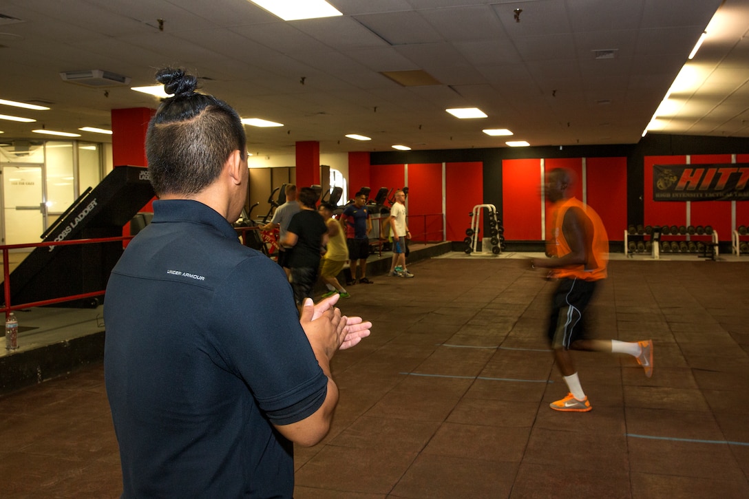 Randy Saldivar, a Return-to-Readiness program trainer, claps and motivates Marines during a lunch-time physical training session at the High Intensity Tactical Training Center aboard Marine Corps Air Station Miramar, Calif., Sept. 8. Saldivar observes training sessions held at the center to ensure safety and injury prevention measures are practiced.