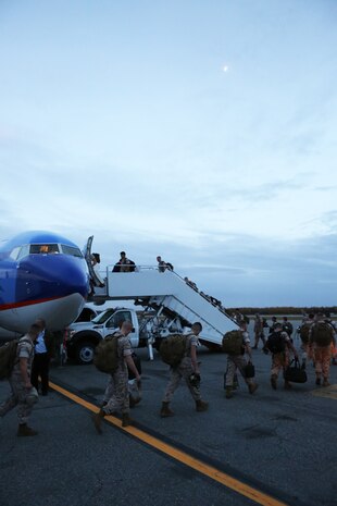 Service members with Marine Fighter Attack Squadron 122 load on to a plane, Sept. 13, 2014, aboard Eielson Air Force Base, Alaska. The plane departed for Marine Corps Air Station Beaufort, S. C., where VMFA-122 is stationed. The Marines and sailors of VMFA-122 completed a six-month deployment throughout the Pacific, where they participated in many joint service exercises and unit level training.