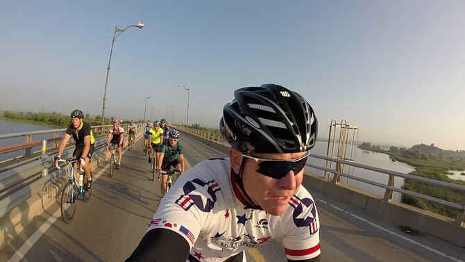 Bill Goins, 8th Medical Operations Support health promotion program coordinator, bikes over a bridge as part of a nine-person team during a 125-mile bike ride from Osan Air Base, Republic of Korea, to Kunsan AB, Aug. 30, 2014. Goins and Wolf Pack Airmen have been making the annual trek for seven years. (Courtesy photo by Bill Goins)