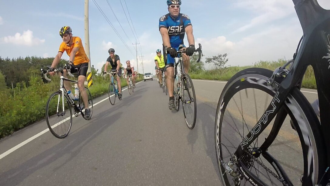 Wolf Pack Airmen from Kunsan Air Base, Republic of Korea, bike on a road during a 125-mile trek from Osan AB to Kunsan AB, Aug. 30, 2014. Bill Goins, 8th Medical Operations Squadron health promotion program coordinator, has been making the trek since 2008 and leads it annually. (Courtesy photo by Bill Goins)