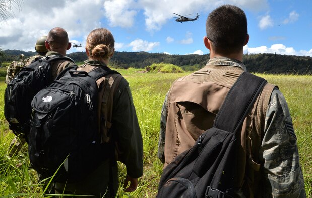 Aircrew members from the 535th Airlift Squadron, 65th AS and 96th Air Refueling Squadron watch as Army UH-60 Black Hawks prepare to land and receive them for an evacuation during a Wing Warrior Day training and exercise Sept. 12, 2014, at Kahuku Training Area on Oahu, Hawaii. The training was a refresher Survival, Evasion, Resistance and Escape course for the aircrew, and required them to evade enemy combatants, find and secure a safe area to stay overnight and establish communication with rescue units for an evacuation. Army and Marine aircraft and personnel also participated in the Warrior Day. (U.S. Air Force photo by Staff Sgt. Alexander Martinez)