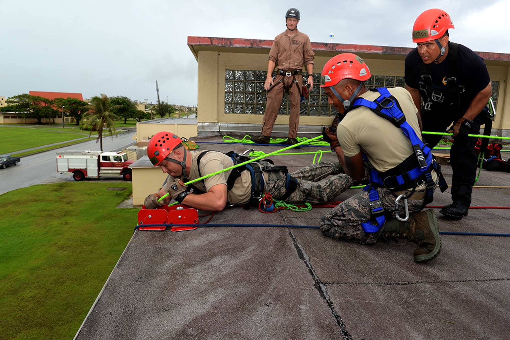 Master Sgt. Jason Berry, 554th RED HORSE Squadron fire and emergency services superintendent (right,) supervises Andersen Air Force Base and Naval Base Guam firefighters secure a simulated victim on the roof of the Hot Spot during the Department of Defense Rescue Technician course event Sept. 16th, 2014, on Andersen. Firefighters attending the course were tasked with rescuing two stranded victims from the Hot Spot as part of their qualification to become rescue technicians. (U.S. Air Force photo by Tech. Sgt. Zachary Wilson/Released.) 