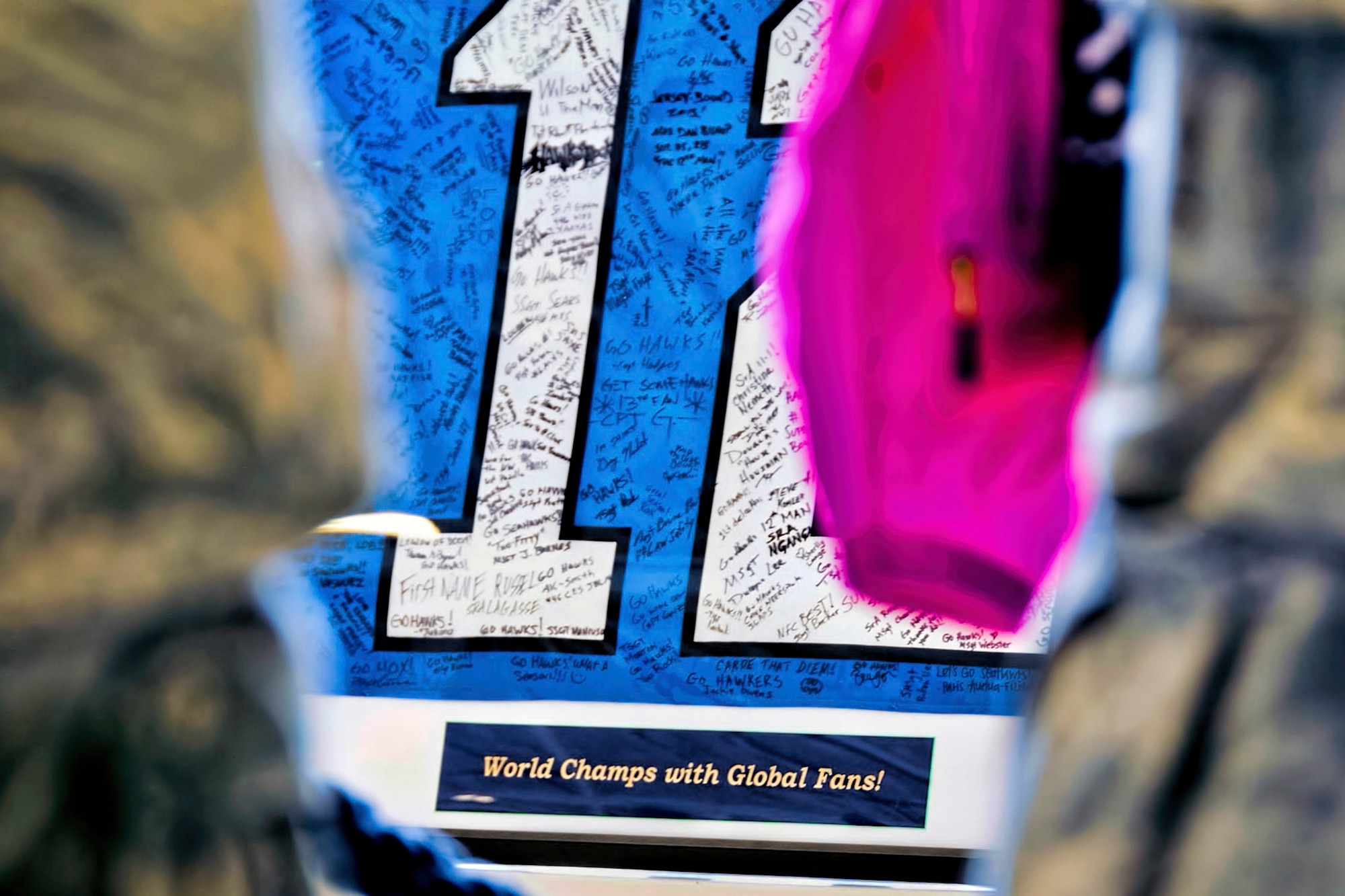 During the Seattle  Seahawks military unit "change of command" at McChord Field, Washington Sept. 9, the 446th Airlift Wing presented the Seahawks with a large 12th Man Flag autographed by members of the wing, even those deployed in places like Southwest Asia and New Zealand. The 446th Airlift Wing handed over the reins as the championship football team's military unit for the season to the Coast Guard District 13 Seattle. (U.S. Air Force Reserve photo by Jake Chappelle)