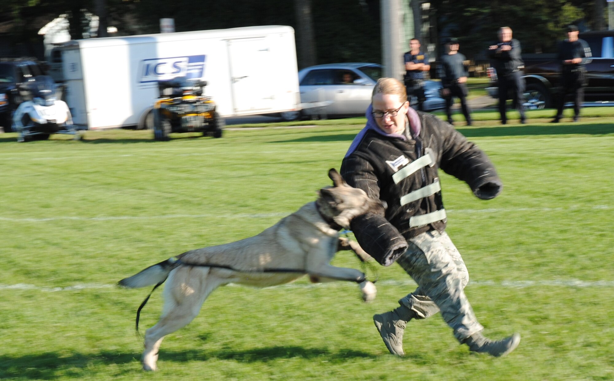 319th Security Forces Squadron Military Working Dog Arco executed his handlers command and launches into attack mode by going for the right arm of Airman 1st Class Sarah Yandell, who volunteered to be a simulated aggressor during a dog demonstration Sept. 15, 2014, at the grounds of the Cliff Fido Purpur Arena in downtown Grand Forks, N.D. The Airmen used MWDs Arco and Zero for the demo.(U.S. Air Force photo/Staff Sgt. Luis Loza Gutierrez) 

