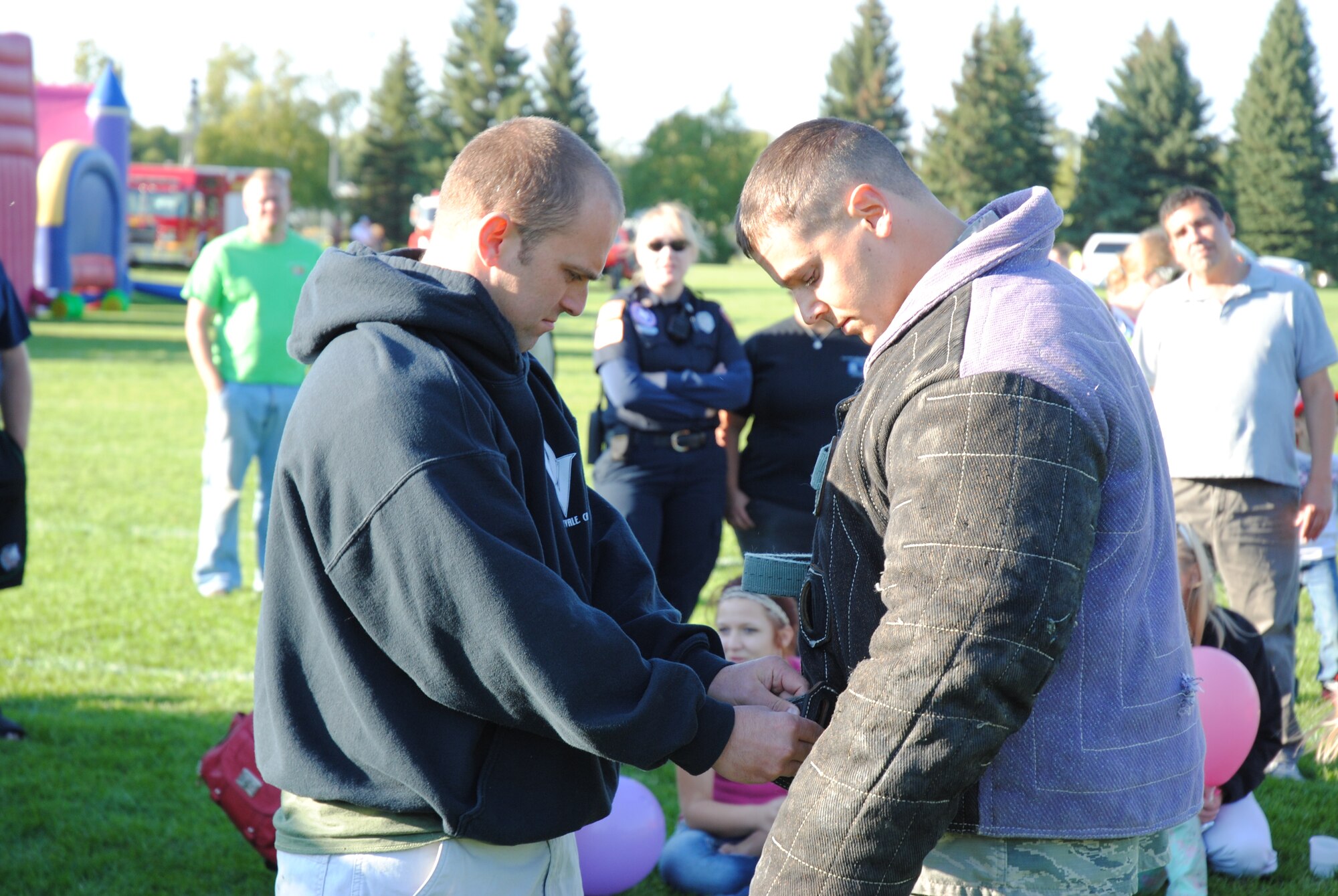 Staff Sgt. Sean King helps fellow 319th Security Forces dog handler Staff Sgt. Brett Silmon prepare  to volunteer and be a non-compliant decoy during a dog demonstration Sept. 15, 2014, at the grounds of the Cliff Fido Purpur Arena in downtown Grand Forks. The NCOs and Arco were part of a 10-member team from the 319th SFS that participated in the free public event. (U.S. Air Force photo/Staff Sgt. Luis Loza Gutierrez) 

