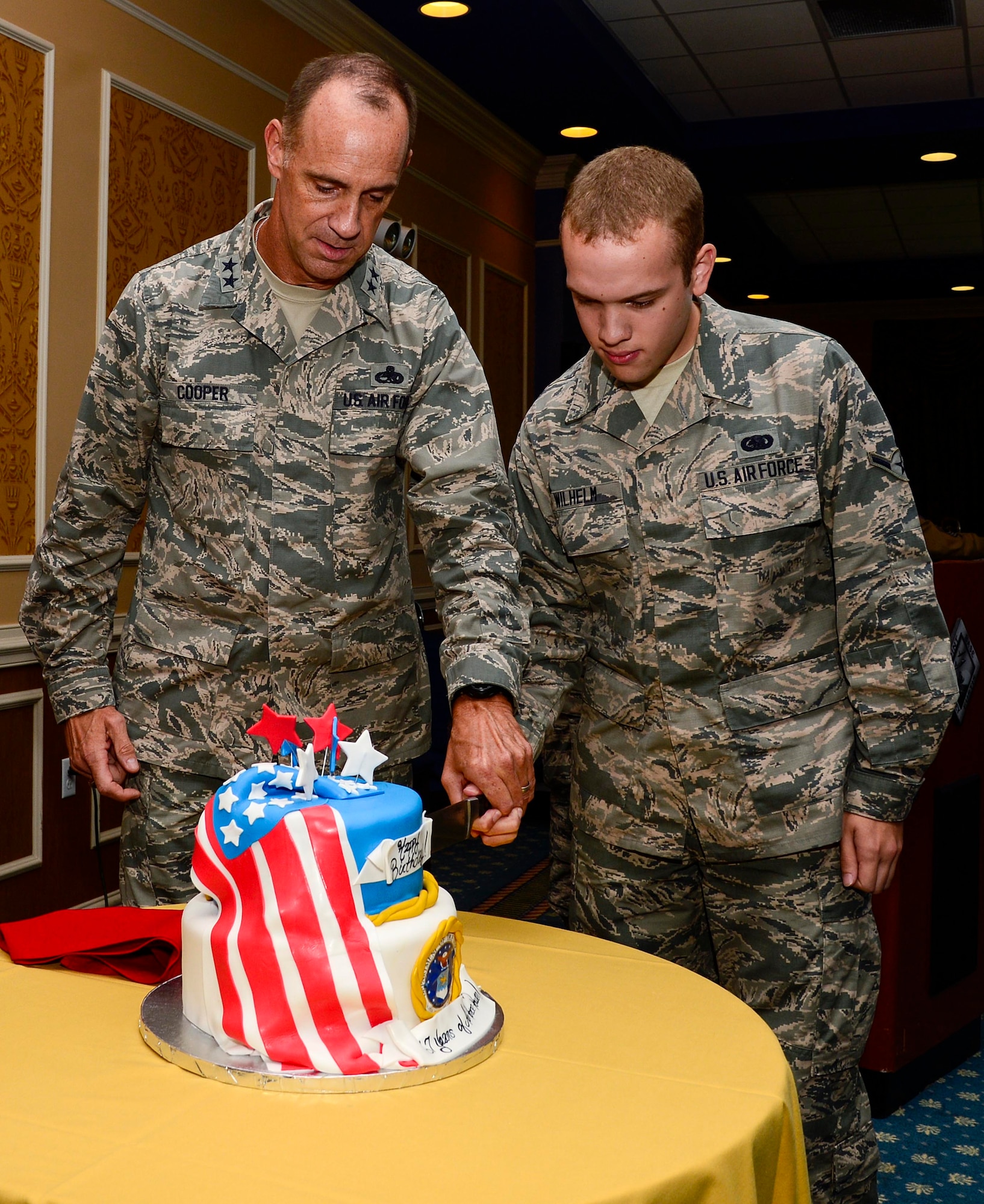 U.S. Air Force Maj. Gen. John Cooper, Headquarters Air Combat Command director of logistics, and Airman Mason Wilhelm, 633rd Logistics Readiness Squadron fuels operator and distribution journeyman, cut the Air Force birthday cake at Langley Air Force Base, Va., Sept. 18, 2014. The Air Force was established in 1947, and U.S. Service members celebrated its 67th birthday throughout Department of Defense installations. (U.S. Air Force photo by Senior Airman Kayla Newman/Released)