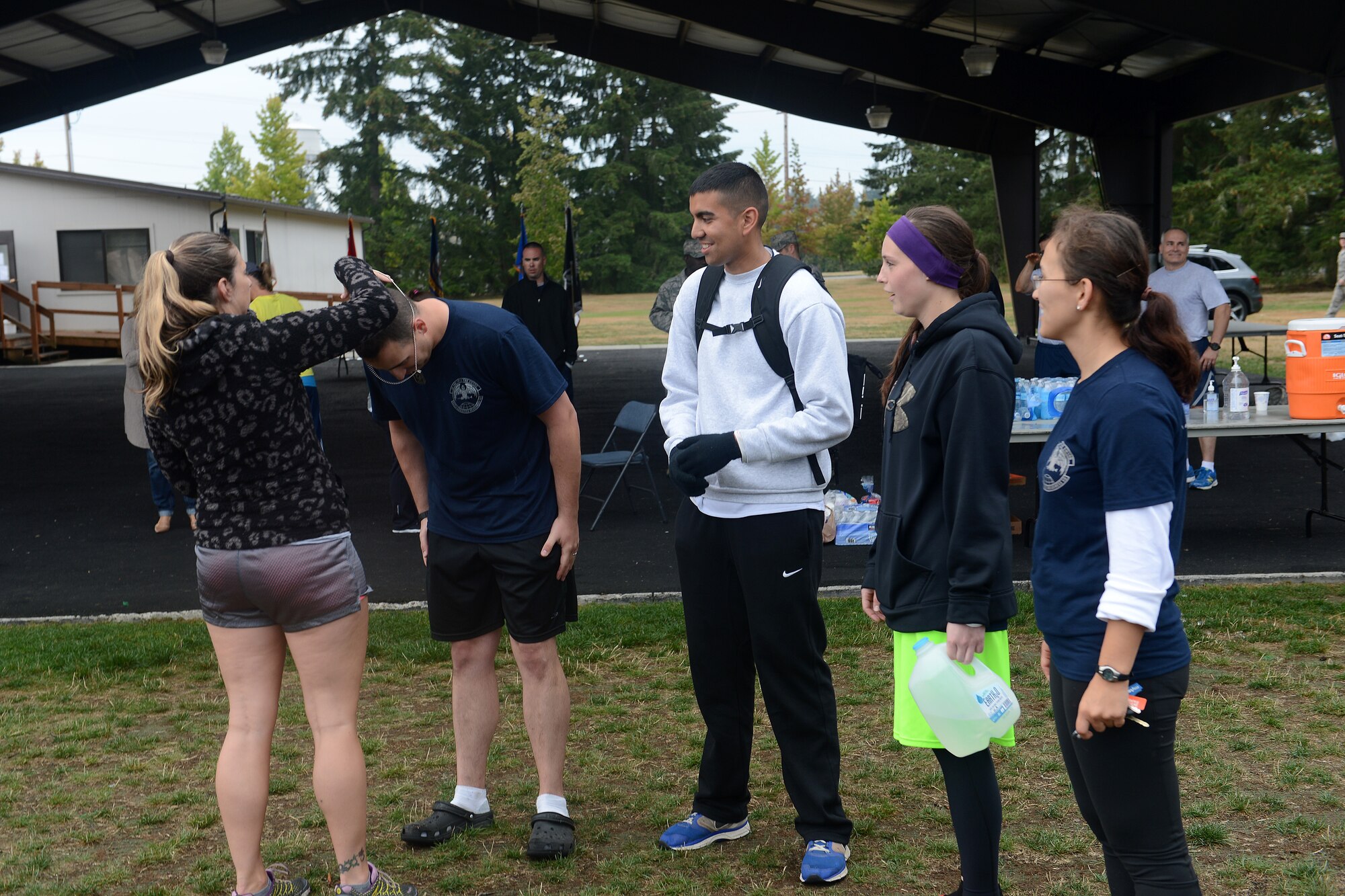 Members from the 627th Logistics Readiness Squadron’s Not Fast Just Furious team, receive key chains for winning 1st place in money donated Sept. 18, 2014, during the 2nd annual POW/MIA 24-hour run’s closing ceremony at Joint Base Lewis-McChord, Wash. Prizes were given out to the teams that ran the most laps, received the most donations, and for the best costume worn during the run. (U.S. Air Force photo/Airman 1st Class Keoni Chavarria)