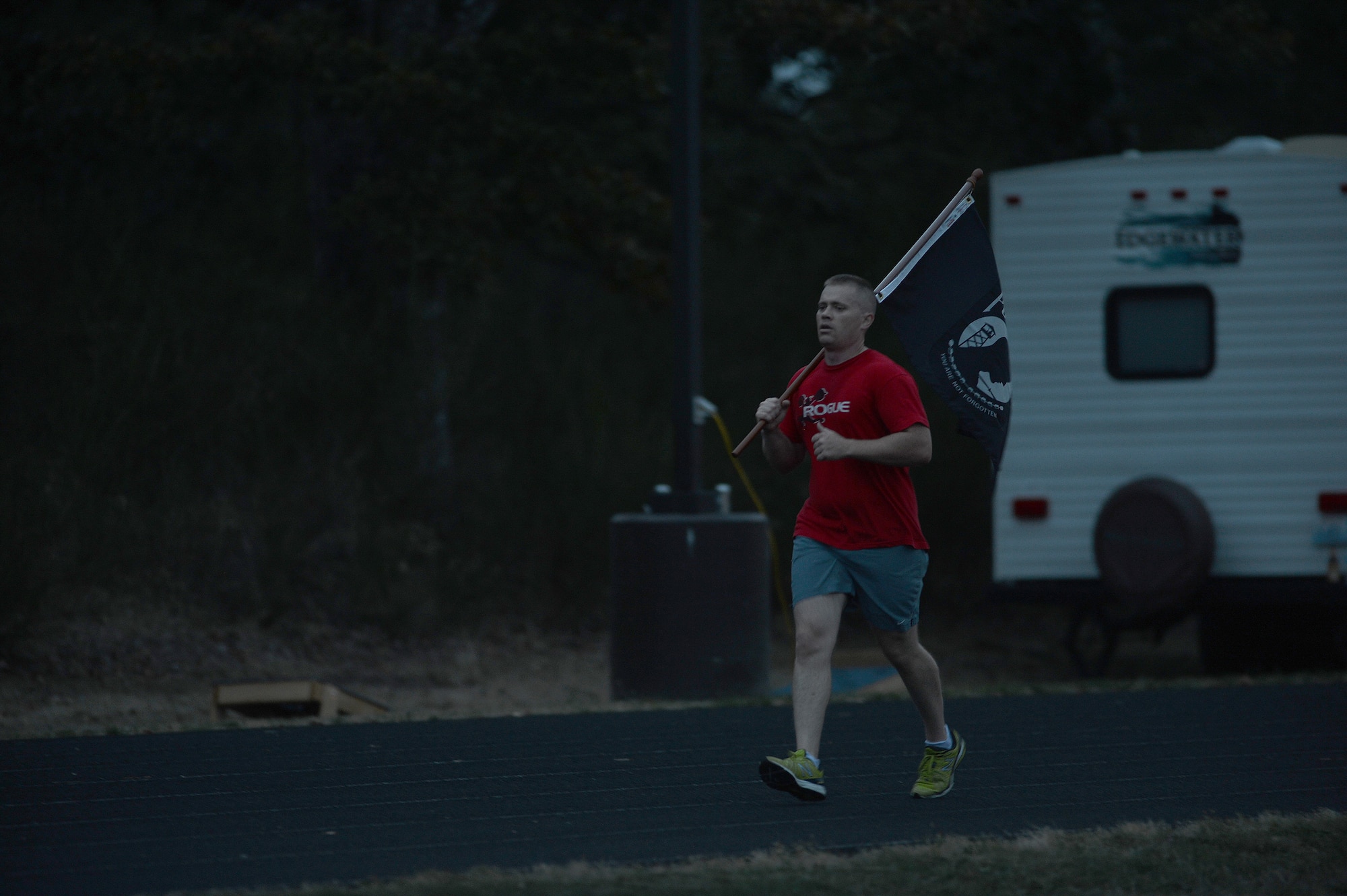 Master Sgt. Chapin Johnston, 627th Force Support Squadron Olympic Dining Facility manager, carries the POW/MIA flag Sept. 17, 2014, during the 2nd annual POW/MIA 24-hour run at Joint Base Lewis-McChord, Wash. The POW/MIA flag was held throughout the entire duration of the run and was passed amongst the different teams. (U.S. Air Force photo/Airman 1st Class Keoni Chavarria)