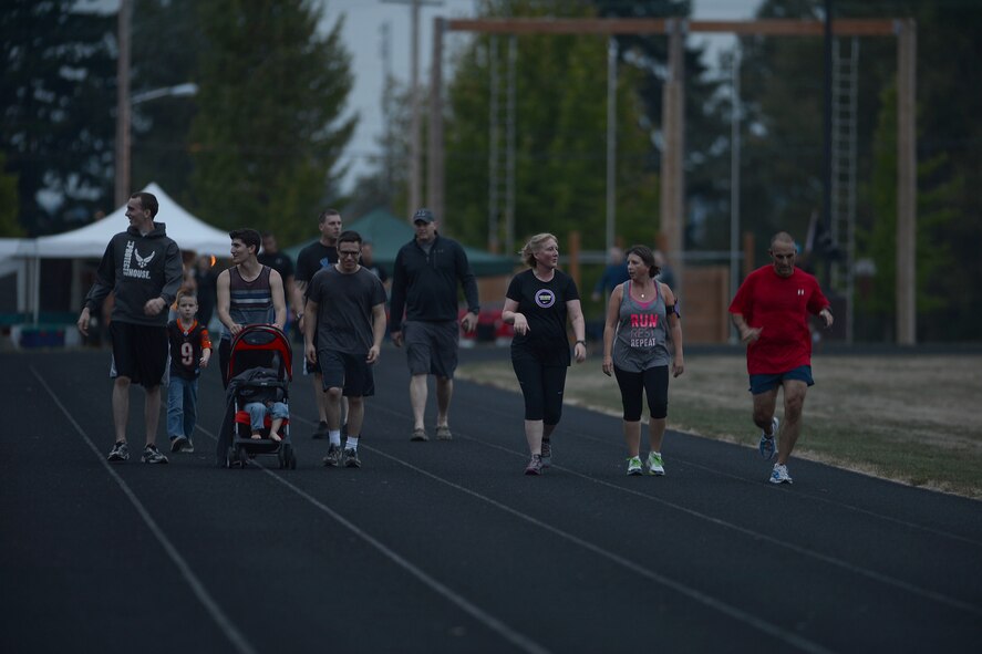As the evening approaches, service members and their families walk on the McChord Field running track Sept. 17, 2014, during the 2nd annual POW/MIA 24-hour run at Joint Base Lewis-McChord, Wash. Airmen from multiple squadrons on base made up teams where a member from each team ran on the track at all times to honor service members who were prisoners of war or are missing in action. (U.S. Air Force photo/Airman 1st Class Keoni Chavarria)