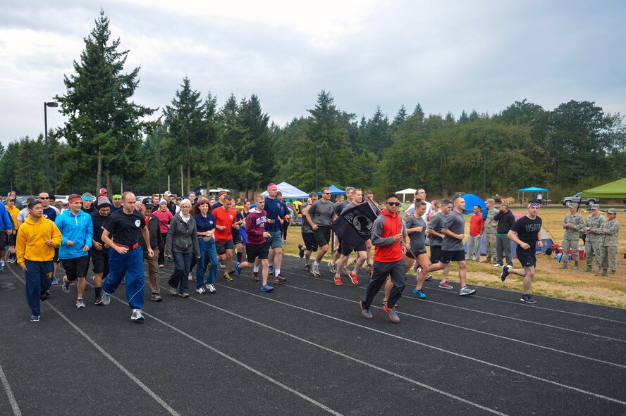 Team McChord Airmen dash from the starting line of the McChord Field running track Sept. 17, 2014, beginning the 2nd Annual POW/MIA 24-hour run at Joint Base Lewis-McChord, Wash. The event afforded Airmen the opportunity to camp in tents, have cookouts on personal grills and even bring their dogs to keep morale high as they ran throughout the night. (U.S. Air Force photo/Staff Sgt. Russ Jackson)

