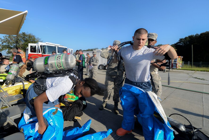 Members of the 23d Civil Engineer Squadron Emergency Management Flight prepare Level A suits during an exercise Sept. 18, 2014, at Moody Air Force Base, Ga. Emergency responders used the suits to investigate possible hazardous material after a simulated vehicle accident. (U.S. Air Force photo by Airman 1st Class Dillian Bamman/Released)