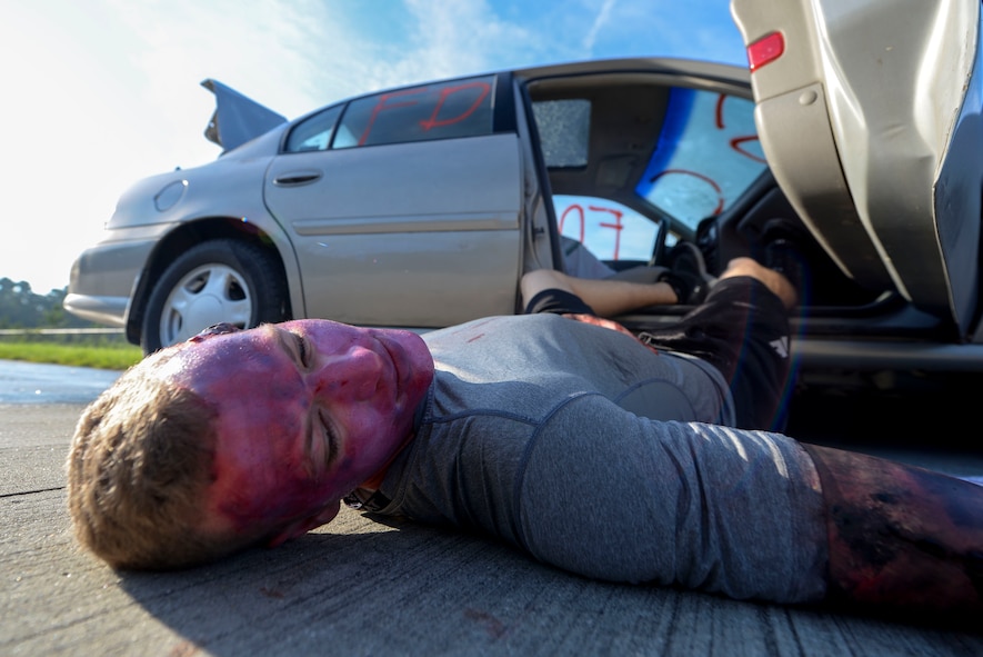 U.S. Air Force Airman 1st Class Jonah Phillips, 822d Base Defense Squadron fireteam member, simulates a killed driver during an exercise Sept. 18, 2014, at Moody Air Force Base, Ga. The exercise scenario involved an accident with a vehicle which contained a simulated mobile methamphetamine laboratory. (U.S. Air Force photo by Airman 1st Class Dillian Bamman/Released)