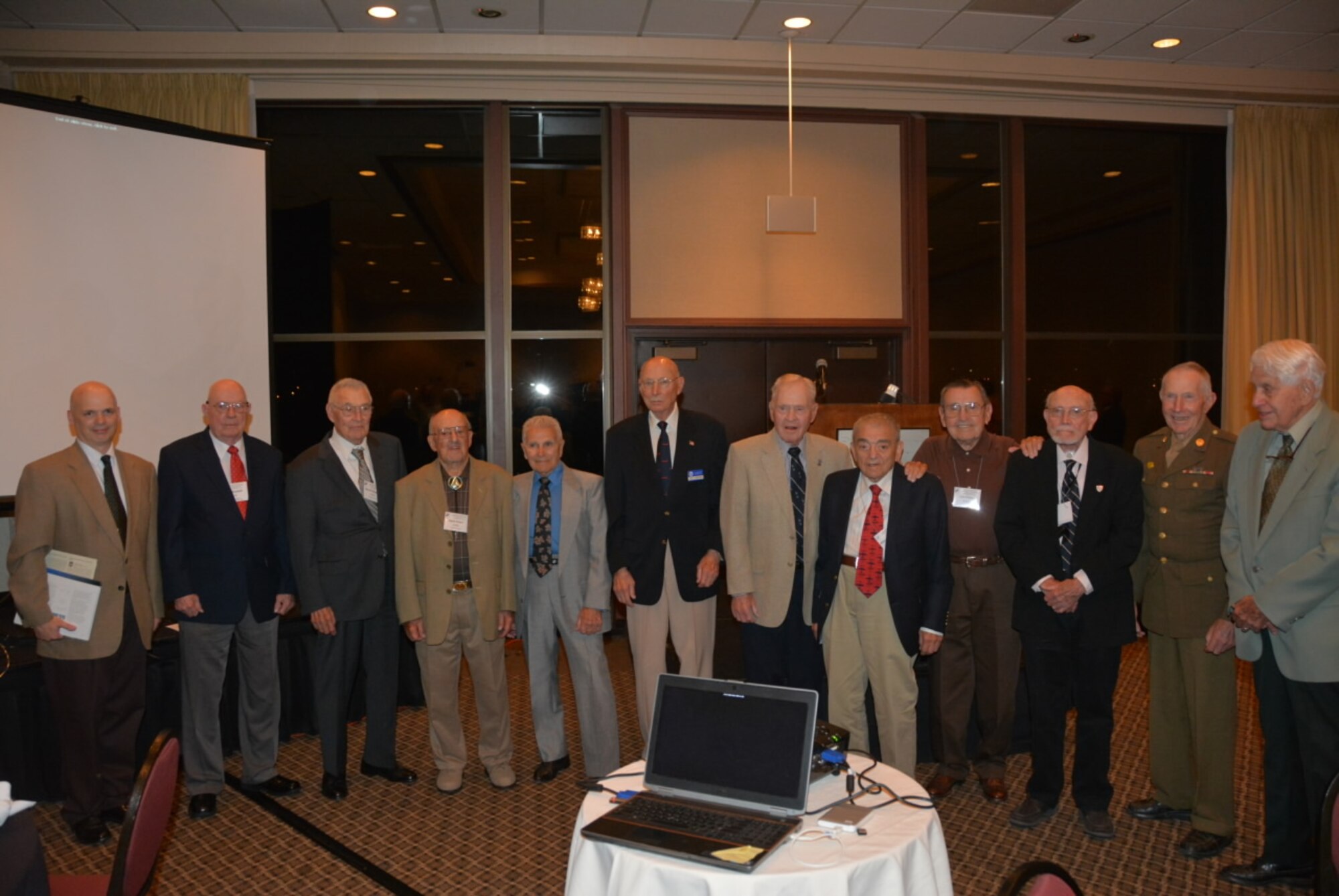 Combat veterans of the 381st Bombardment Group stand to be honored at the 381st Bomb Group (H) Memorial Association’s Banquet in Portland, Oregon, Sept. 6,  2014. The men are, from left to right, guest speaker Terrence Popravak Jr., and 381BG combat veterans Joe Waddell, Darrell Blizzard, Herb Kwart, Lou Perrone, Dick Schneider, Jim Gray, Alex Strohmayer, Leo Foley, Leonard Spivey, Burton Hill, accompanied by a fellow B-17 veteran, Don Hayes  (97th Bomb Group).  (Courtesy Dr. Kevin Wilson, 381BGMA Secretary-Treasurer/Historian)