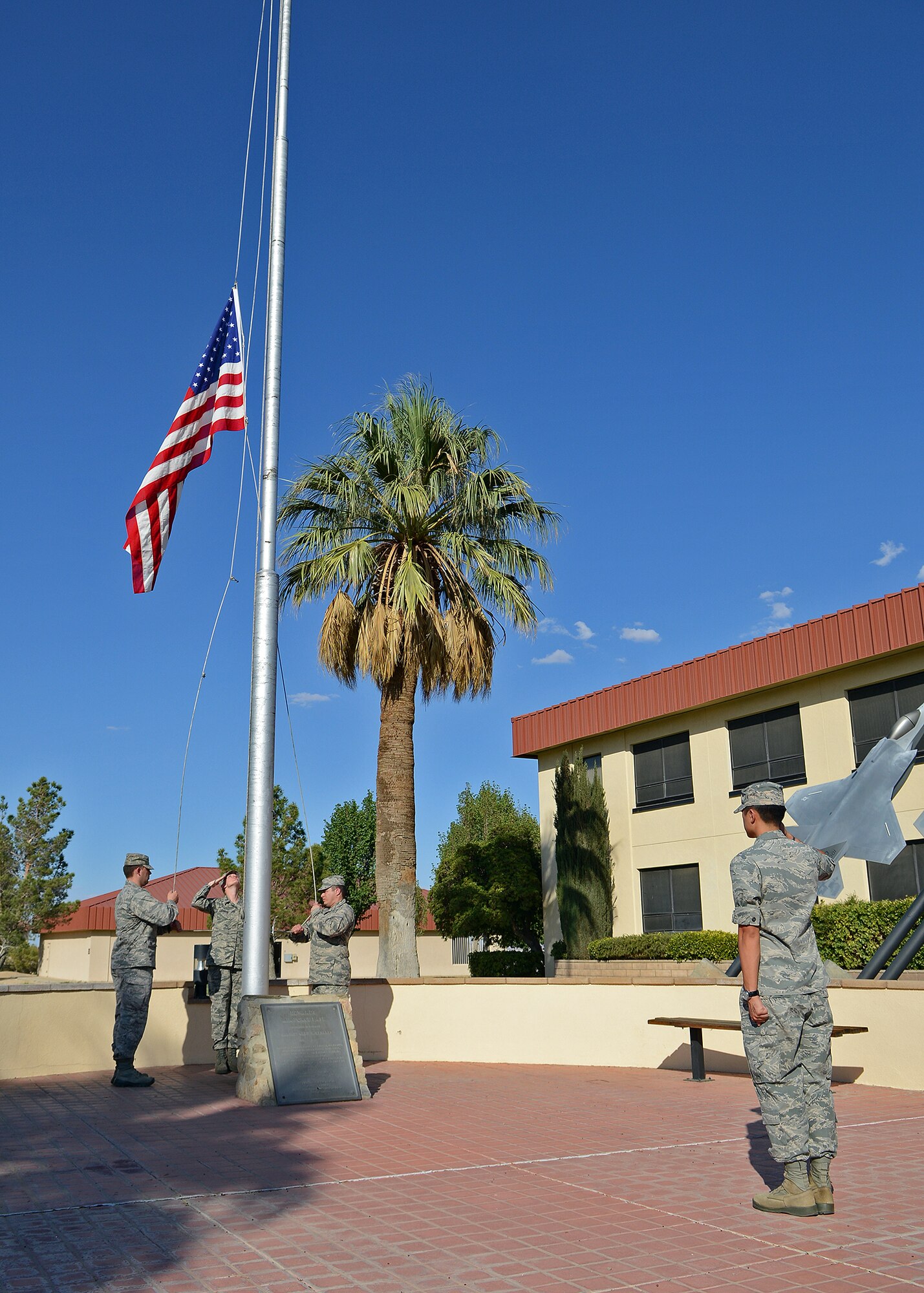 (From right to left) 1st Lt. Tony Liu, from the Air Force Operational Test and Evaluation Center Detachment 1, salutes the American flag as 1st Lt. Michael Eibling, from the U.S. Air Force Test Pilot School, Capt. Shanna Vaughan, from the 412th Medical Support Squadron, and 1st Lt. Jose Pagan Davila, from the 412th Aerospace Medicine Squadron secure the flag during a retreat ceremony Sept. 15 in front of Building 1. The ceremony was held to commemorate the 200th birthday of the United States' National Anthem, "The Star-Spangled Banner," which occurred Sept. 14. (U.S. Air Force photo by Jet Fabara)