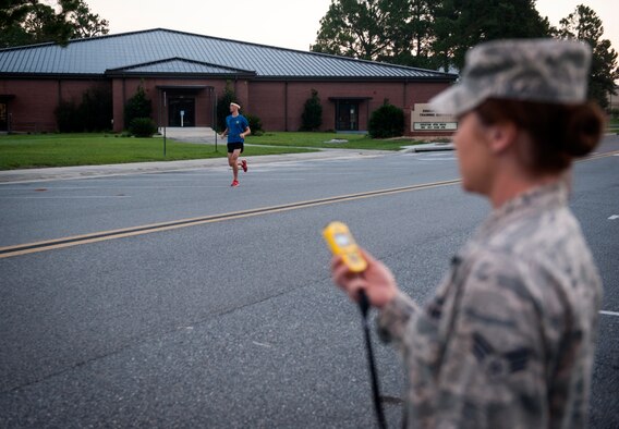 U.S. Air Force Senior Airman Dallas Remonda, 38th Rescue Squadron, runs to the finish line of a 5K run as Senior Airman Rebecca April, 23d Force Support Squadron, monitors a stopwatch Sept. 18, 2014, at Moody Air Force Base, Ga. Dallas finished in first place with a time of 19 minutes, 25 seconds. (U.S. Air Force photo by Senior Airman Jarrod Grammel/Released)
