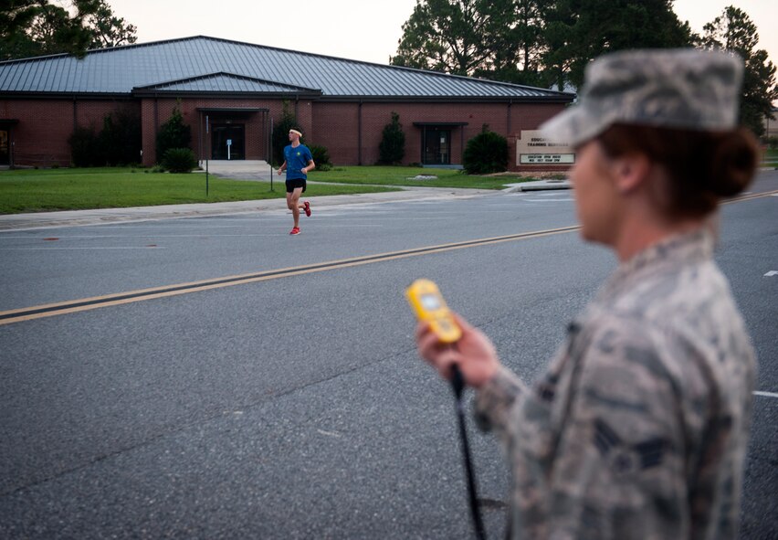 U.S. Air Force Senior Airman Dallas Remonda, 38th Rescue Squadron, runs to the finish line of a 5K run as Senior Airman Rebecca April, 23d Force Support Squadron, monitors a stopwatch Sept. 18, 2014, at Moody Air Force Base, Ga. Dallas finished in first place with a time of 19 minutes, 25 seconds. (U.S. Air Force photo by Senior Airman Jarrod Grammel/Released)
