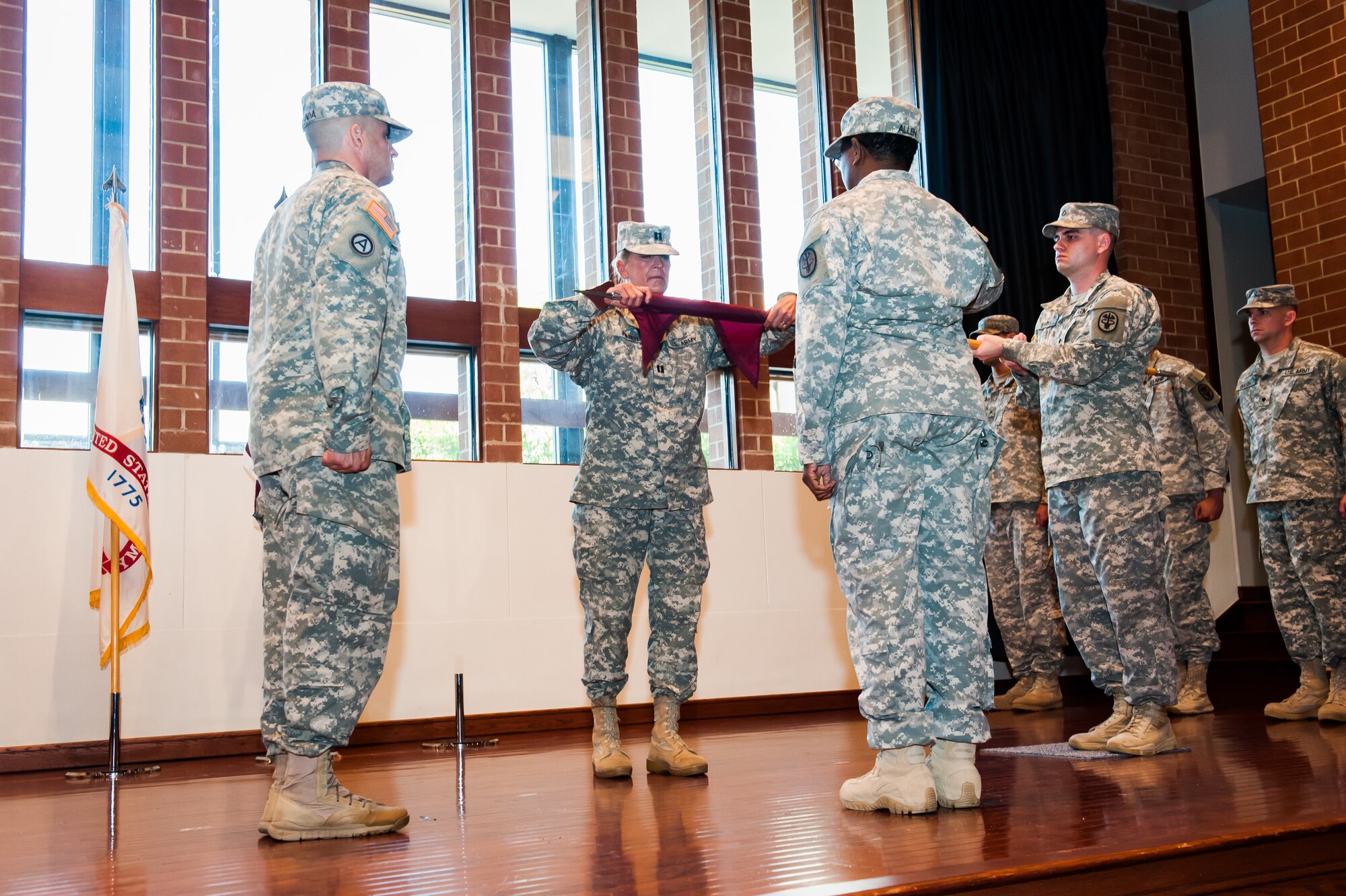 Army Capt. Sharon Rinier, Fort Dix WTU commander, prepares the Warrior Transition Unit guidon for casing of the colors at the units deactivation ceremony held at the Expeditionary Center at Joint Base McGuire-Dix-Lakehurst, N.J., Sept. 4, 2014.  