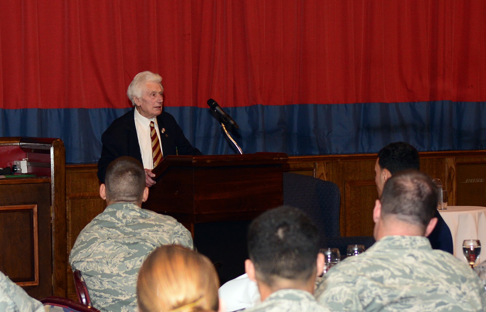 Harry Buckledee, former prisoner of war during World War II from Sudbury, Suffolk, speaks about his time as a POW during the Prisoner of War/Missing in Action Fallen Comrades Committee luncheon Sept. 17, 2014, at the Galaxy Club on RAF Mildenhall, England. American forces rescued Buckledee from his imprisonment April 12, 1944. (U.S. Air Force photo/Airman 1st Class Jonathan Light/Released) 
