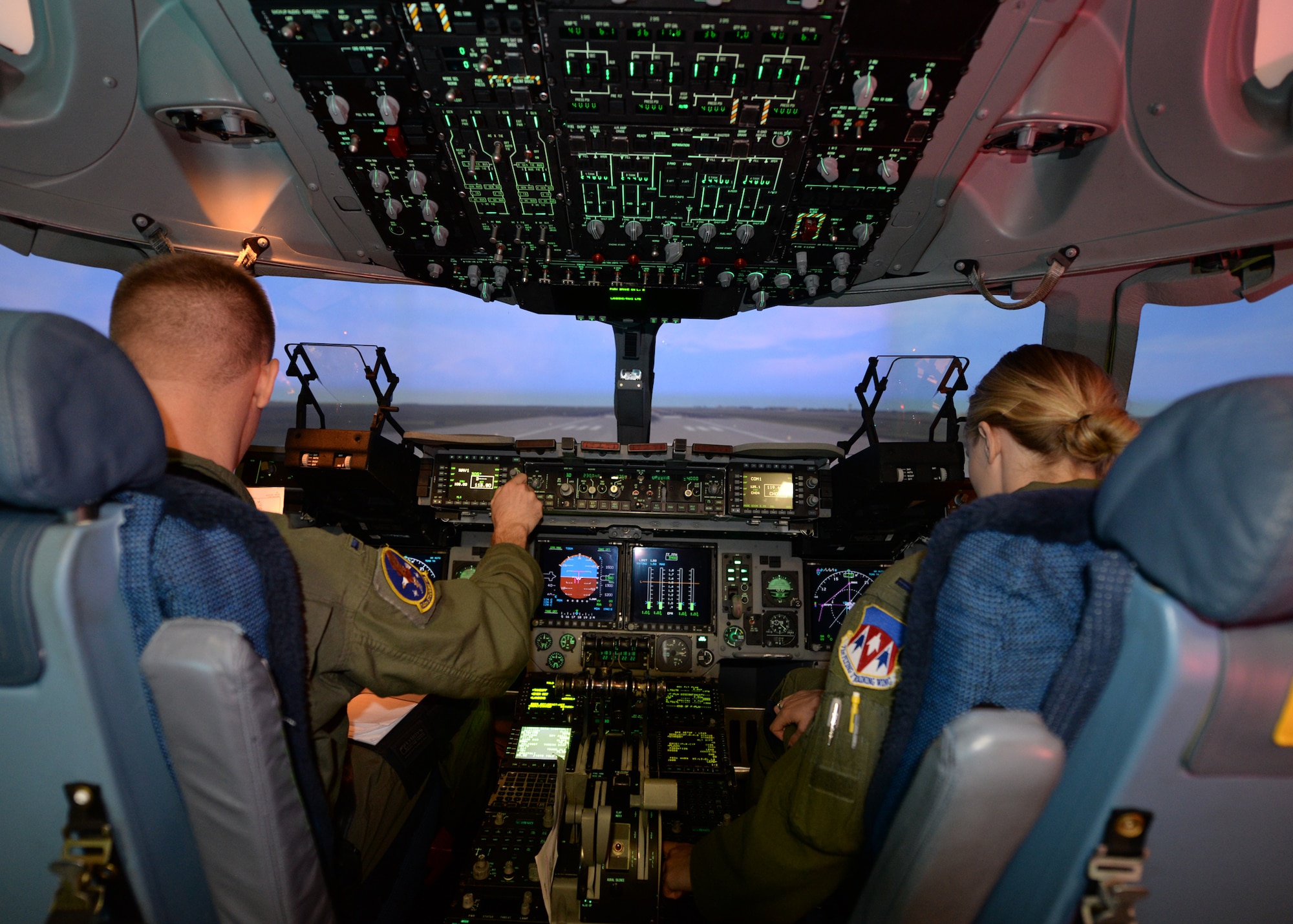 ALTUS AIR FORCE BASE, Okla. – U.S. Air Force 1st Lts. Andrew Crispin and Emily Barkemeyer, C-17 Globemaster III cargo aircraft student pilots, run through the C-17 pre-flight checks in the flight simulator, Sept. 16, 2014. Students spend 136.5 hours in the simulators, the majority of the C-17 pilot course. Simulators operate at five percent of the cost of a real aircraft, saving a substantial amount of money. (U.S. Air Force photo by Airman 1st Class Nathan Clark/Released)