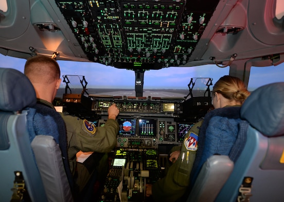 ALTUS AIR FORCE BASE, Okla. – U.S. Air Force 1st Lts. Andrew Crispin and Emily Barkemeyer, C-17 Globemaster III cargo aircraft student pilots, run through the C-17 pre-flight checks in the flight simulator, Sept. 16, 2014. Students spend 136.5 hours in the simulators, the majority of the C-17 pilot course. Simulators operate at five percent of the cost of a real aircraft, saving a substantial amount of money. (U.S. Air Force photo by Airman 1st Class Nathan Clark/Released)