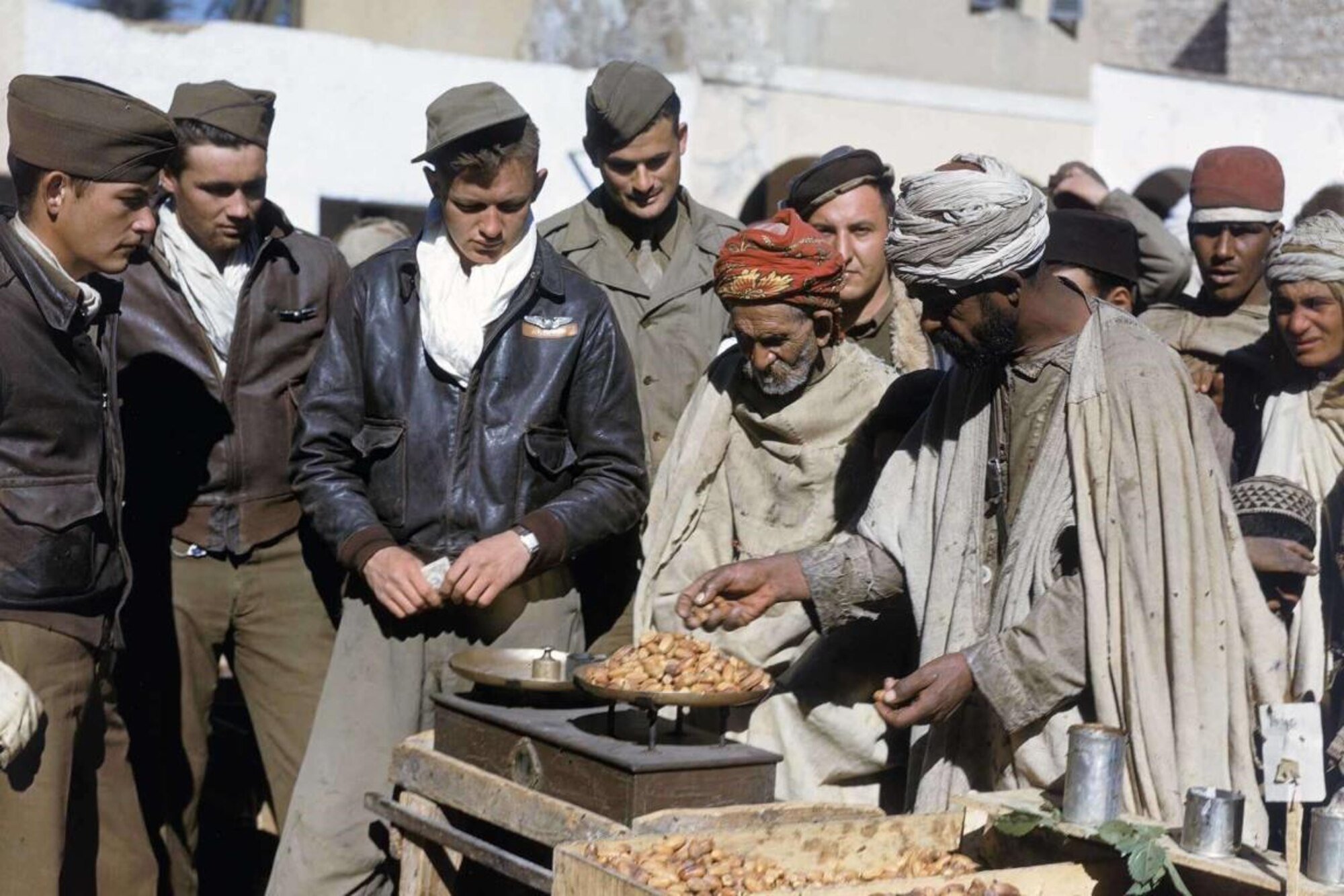 In December 1943/January 1944, several 12th Air Force enlisted aircrew members barter with local Arabs for dates while stationed in Algeria. (Courtesy Photo) 