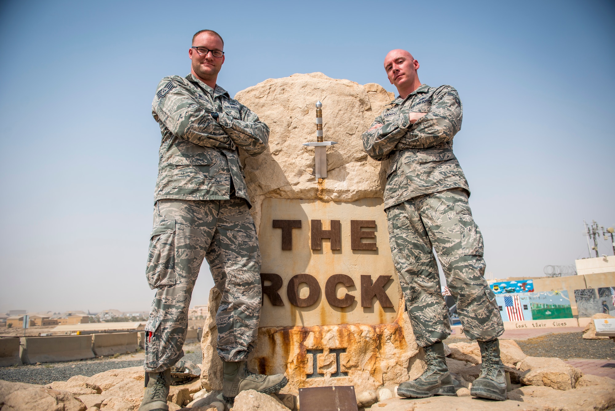 U.S. Air Force Staff Sgts. Justin Costanzo and Jarrod McMillian, 386th Expeditionary Maintenance Squadron aircraft maintenance technicians, pose in front of The Rock after unveiling the new sword to the 386th Air Expeditionary Wing Aug. 19, 2014 at an undisclosed location in Southwest Asia. The two spent over 140 man-hours designing and building the sword. Costanzo deployed from Shaw Air Force Base, S.C. and McMillian deployed from Davis-Monthan AFB, Ariz. in support of Operation Enduring Freedom. (U.S. Air Force photo by Staff Sgt. Jeremy Bowcock)