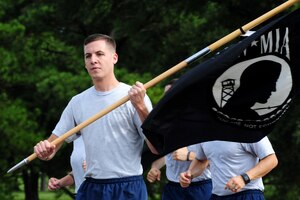 U.S. Air Force Airman 1st Class Mark Underhill, 633 Medical Operations Squadron pediatric medical technician, carries the POW/MIA flag into the 2014 POW/MIA Ceremony at Langley Air Force Base, Va., Sept. 17, 2014. Underhill said he wanted to honor his step grandfather, U.S. Army Sgt. Charles Layton, who was held captive for 17 weeks during the Korean War. (U.S. Air Force photo by Airman 1st Class Areca T. Wilson/Released) 