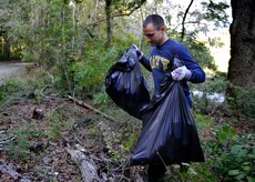 Chief Petty Officer Selectee Jon Everett, Naval Nuclear Power Training Command, collects debris from the Peas Hill Creek during a chief petty officer selectee community project Sept. 13, 2014, near James Island, S.C. Chief selectees participate in COMREL projects as part of the CPO 365 Phase 2 training. The project was coordinated with Keep Charleston Beautiful, an organization that encourages local groups to volunteer for clean-up projects across the state by providing trash bags, gloves and any necessary supplies they might need. The chief selectees pinned on their anchors Sept. 16. (U.S. Air Force photo/Staff Sgt. Renae Pittman)