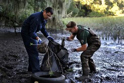 Chief Petty Officer Selectees James Holman and Matt Ryals, Naval Nuclear Power Training Command, collect debris from the Peas Hill Creek during a chief petty officer selectee community project Sept. 13, 2014, near James Island, S.C.. Chief selectees participate in COMREL projects as part of the CPO 365 Phase 2 training. The project was coordinated with Keep Charleston Beautiful, an organization that encourages local groups to volunteer for clean-up projects across the state by providing trash bags, gloves and any necessary supplies they might need. The chief selectees pinned on their anchors Sept. 16. (U.S. Air Force photo/Staff Sgt. Renae Pittman)