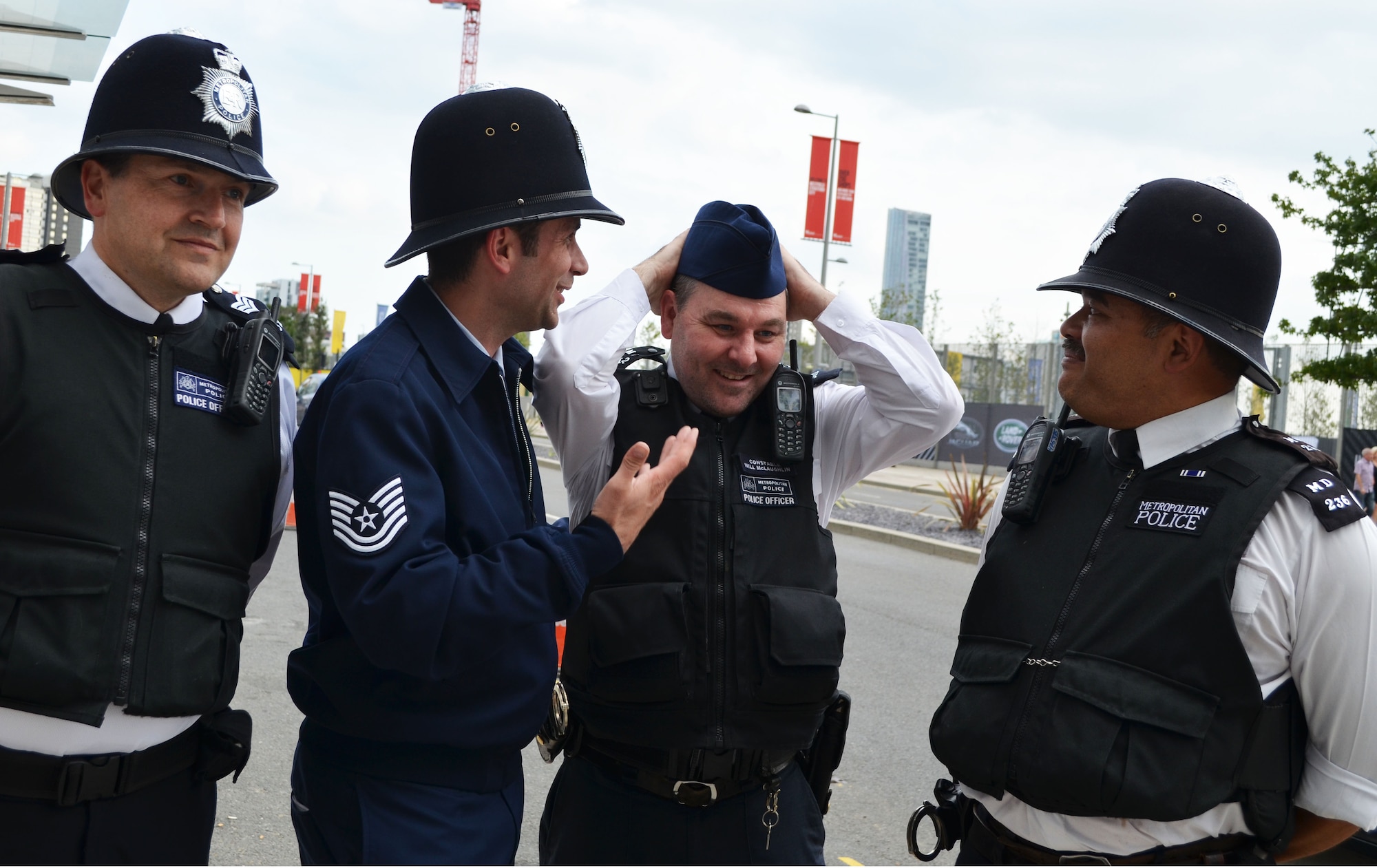 U.S. Technical Sgt. Steven Van Gorden, executive assistant to the vice commander, U.S. Air Forces in Europe-Air Forces Africa, swaps headwear with a Constable Will McLaughlin, Metropolitan Police Officer, outside Queen Elizabeth Olympic Park in London. The Metropolitan Police provided security throughout the duration of the Invictus Games. (U.S. Air Force photo by Capt. Carolyn Glover/Released)