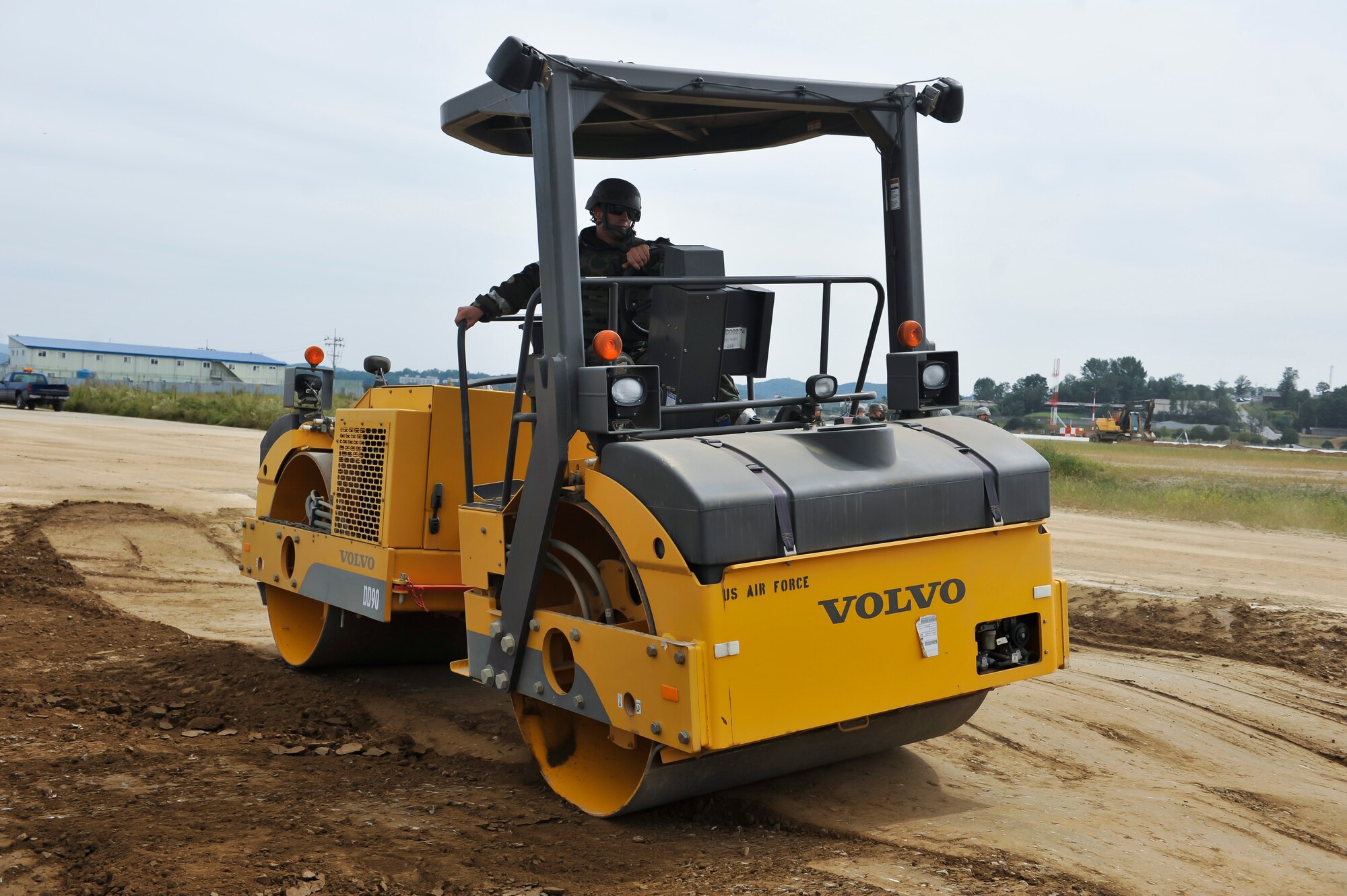Airman 1st Class Joseph Morrison, 51st Civil Engineer Squadron pavement and equipment journeyman, levels the dirt in the crater on a flight line training site during a simulated crater repair for operational readiness exercise Beverly Midnight 14-4 Sept. 18, 2014, at Osan Air Base, Republic of Korea. Airmen place a folded fiberglass mat over the crater once it has been completely leveled. (U.S. Air Force photo by Senior Airman David Owsianka)
