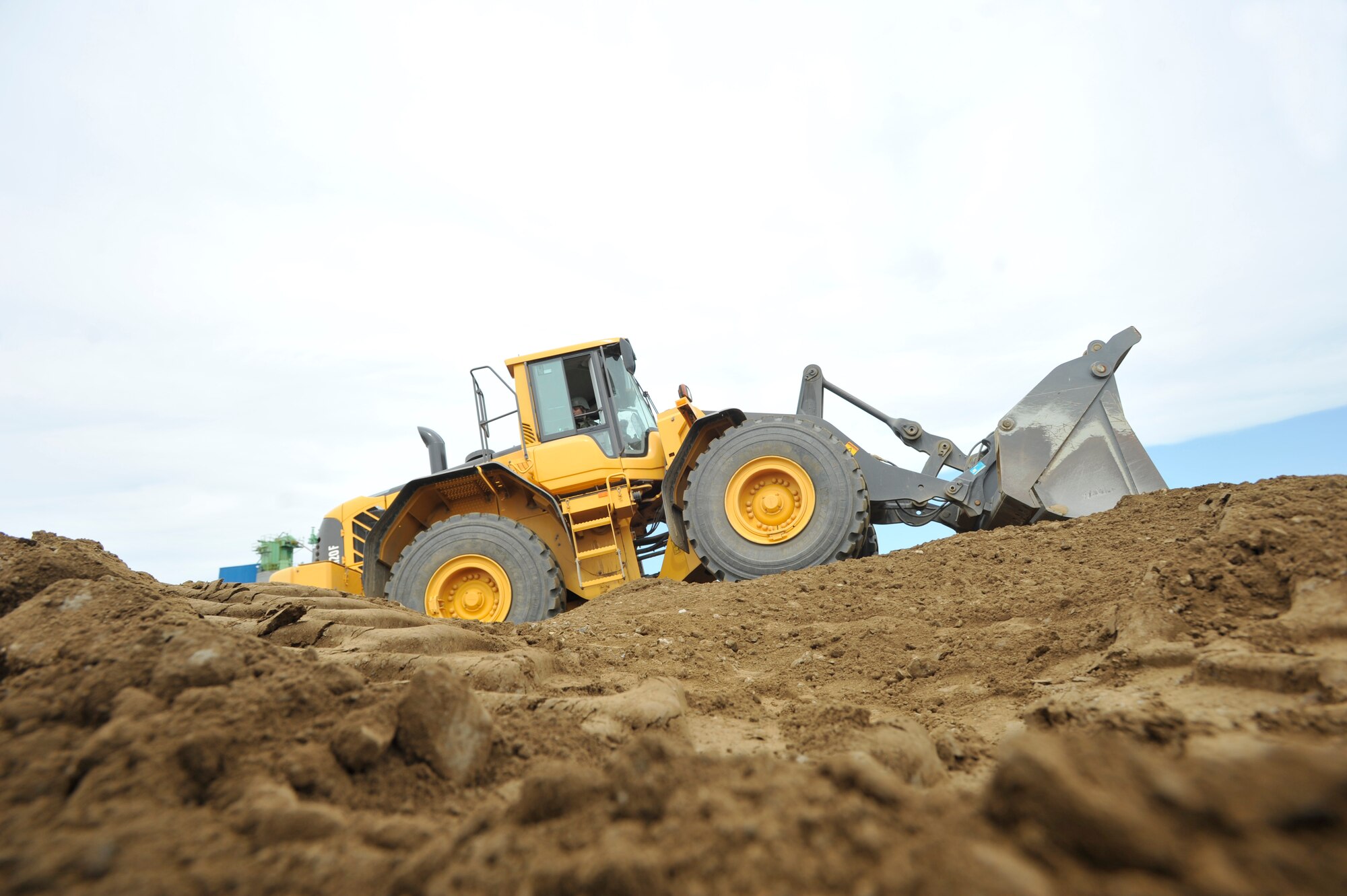 Senior Airman Kevin Bittinger, 51st Civil Engineer Squadron pavement and equipment journeyman, levels the dirt in the crater on a flight line training site during a simulated crater repair for operational readiness exercise Beverly Midnight 14-4 Sept. 18, 2014, at Osan Air Base, Republic of Korea. In real world scenarios, Airmen will fill and compact the crater with crushed stone. (U.S. Air Force photo by Senior Airman David Owsianka)