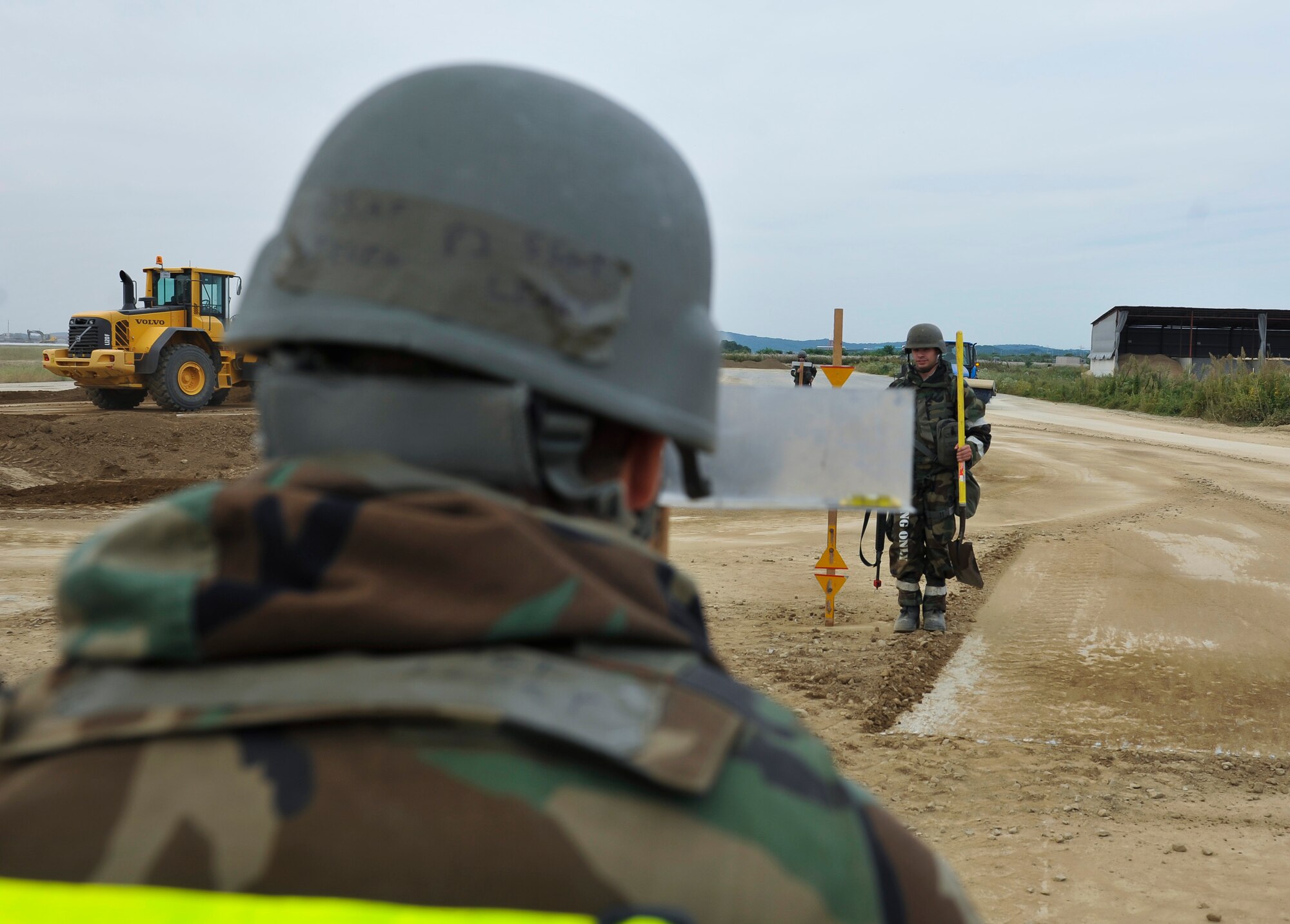 Airmen from the 51st Civil Engineer Squadron check to ensure the ground is level after moving the dirt and debris from the crater on a flight line training site during a simulated crater repair for operational readiness exercise Beverly Midnight 14-4 Sept. 18, 2014, at Osan Air Base, Republic of Korea. This training provides the Airmen an opportunity to practice and hone their wartime capabilities. (U.S. Air Force photo by Senior Airman David Owsianka)