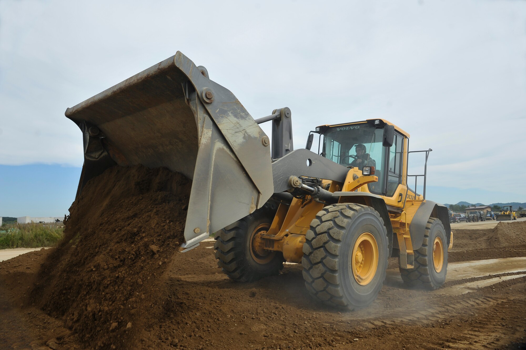 Senior Airman Samuel Ziegler, 51st Civil Engineer Squadron pavement and equipment journeyman, places dirt away from the crater on a flight line training site during a simulated crater repair for operational readiness exercise Beverly Midnight 14-4 Sept. 18, 2014, at Osan Air Base, Republic of Korea. In a real world scenario, the Airmen will clear the debris from the crater at least 20 feet in all directions. (U.S. Air Force photo by Senior Airman David Owsianka)