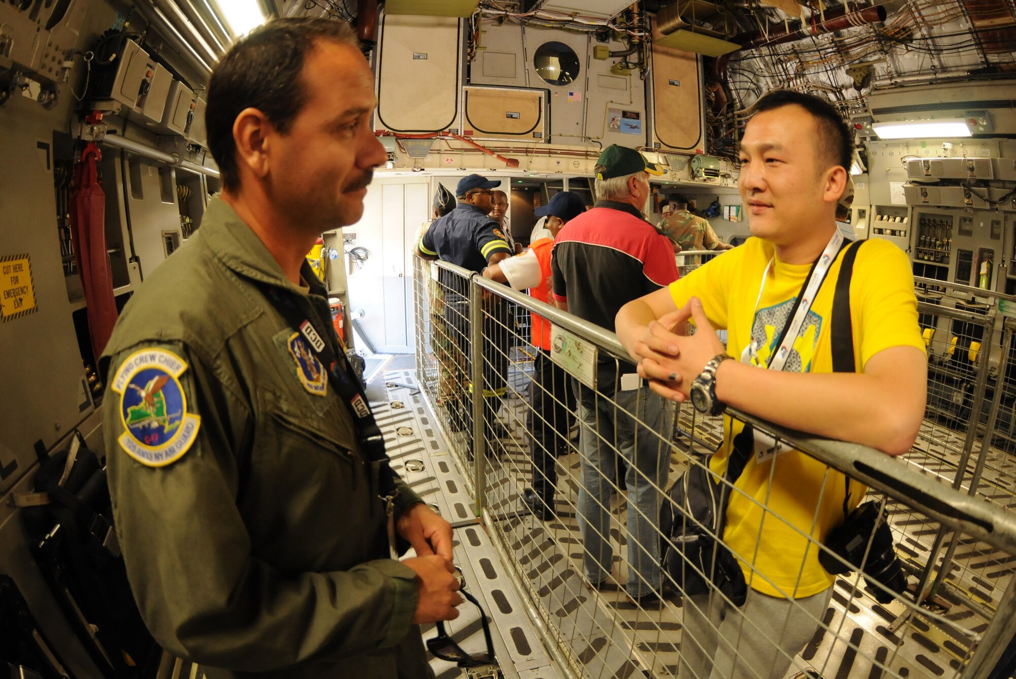 Tech. Sgt. Alex Quintero, a flying crew chief from the New York Air National Guard's 105th Airlift Wing, chats with a spectator about his role on the C-17 Globemaster III during the opening day of the Africa Aerospace & Defence Expo 2014 Sept. 17, 2014, at Waterkloof Air Force Base, Pretoria, South Africa. U.S. Air Force Airmen and U.S. Army Soldiers attended the opening day of the 8th annual multinational event. United States military aircraft, including a C-130J Super Hercules and C-17 were on static display at the show, and the U.S. Army Golden Knights parachute demonstration team jumped into the opening ceremony alongside their South African counterparts, the Golden Eagles. (U.S. Air Force photo by Tech. Sgt. Austin M. May/Released)