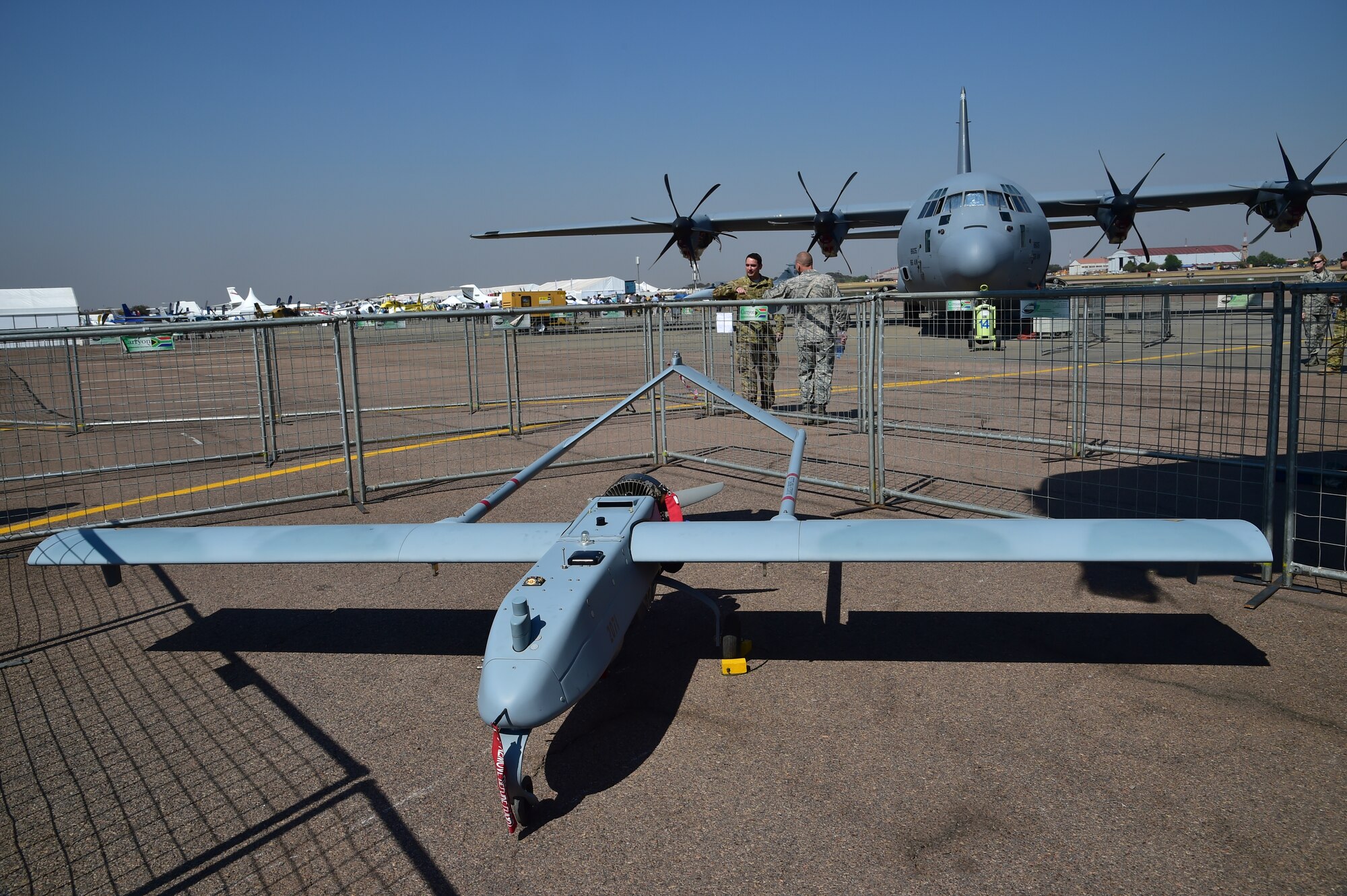 An RQ-7 Shadow and C-130J Super Hercules await visitors and aircraft enthusiasts at the Africa Aerospace and Defence Expo 2014 Sept. 17, 2014, at Waterkloof Air Force Base, South Africa. Airmen from Ramstein Air Base, Germany, came to support the African air and trade show as well as to showcase the C-130 and answer questions the public may have about the Air Force aircraft. (U.S. Air Force photo/Staff Sgt. Travis Edwards-Released) 