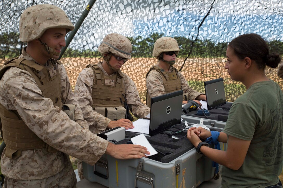 Lance Cpl. Ana L. Ramirezjimenez, right, a Dallas, Texas, native, participates in non-combatant evacuation operations Aug. 21 at the Central Training Area. Ramirezjimenez role played as an evacuee during the scenario who was processed through the control center. Ramirezjimenez is a warehouse clerk with Combat Logistics Battalion 4, 3rd Marine Logistics Group, III Marine Expeditionary Force. The control center Marines are with Combat Logistics Regiment 3, 3rd MLG. (U.S. Marine Corps photo by Lance Cpl. Matt Myers/Released)